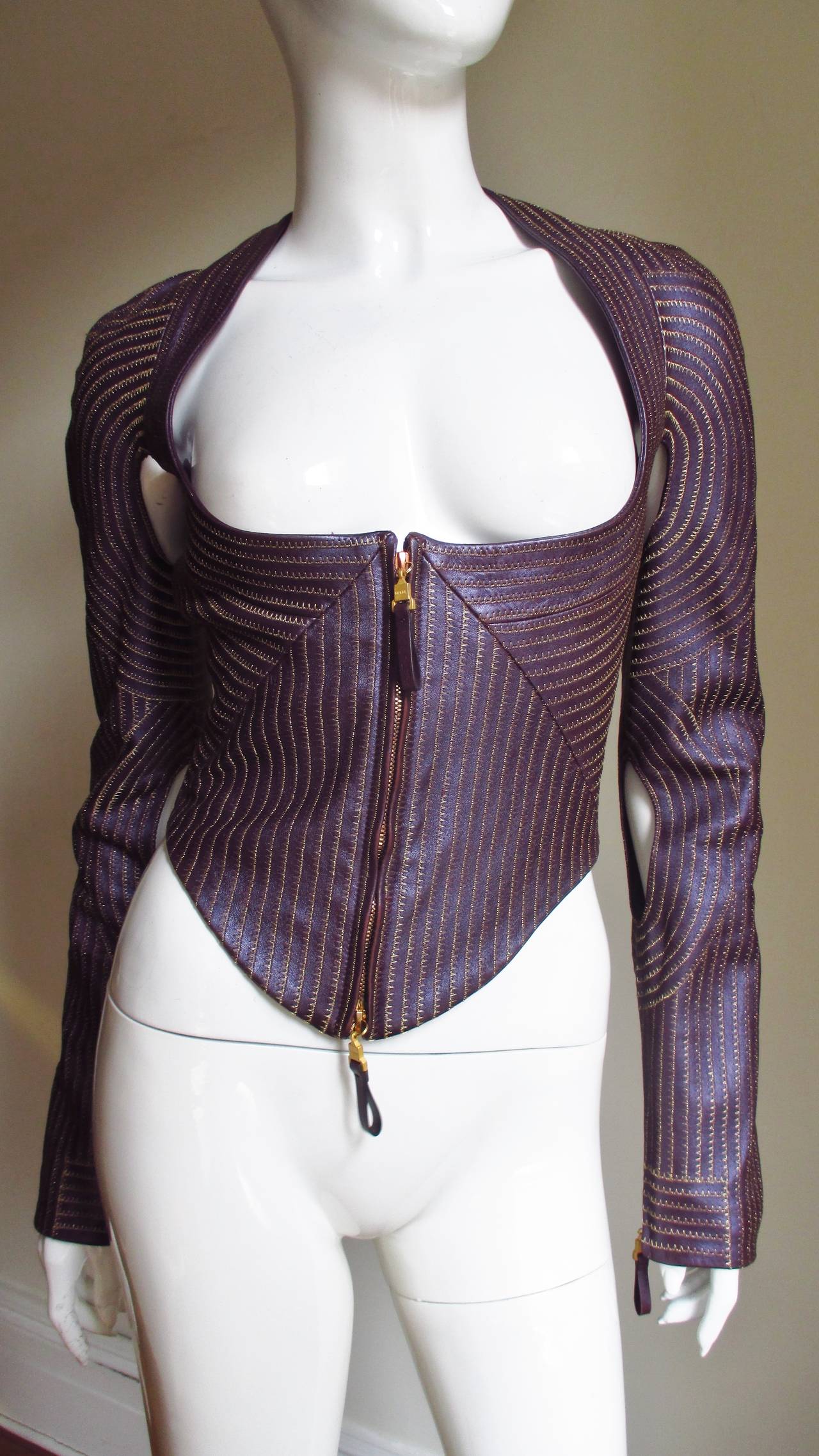 An incredible purple fine leather jacket from Gianfranco Ferre with rows of gold top stitching throughout-  very detailed.  It is fitted with a wide deep scoop neck, long slim sleeves with cutouts under the arms and at the inner elbow, and it is