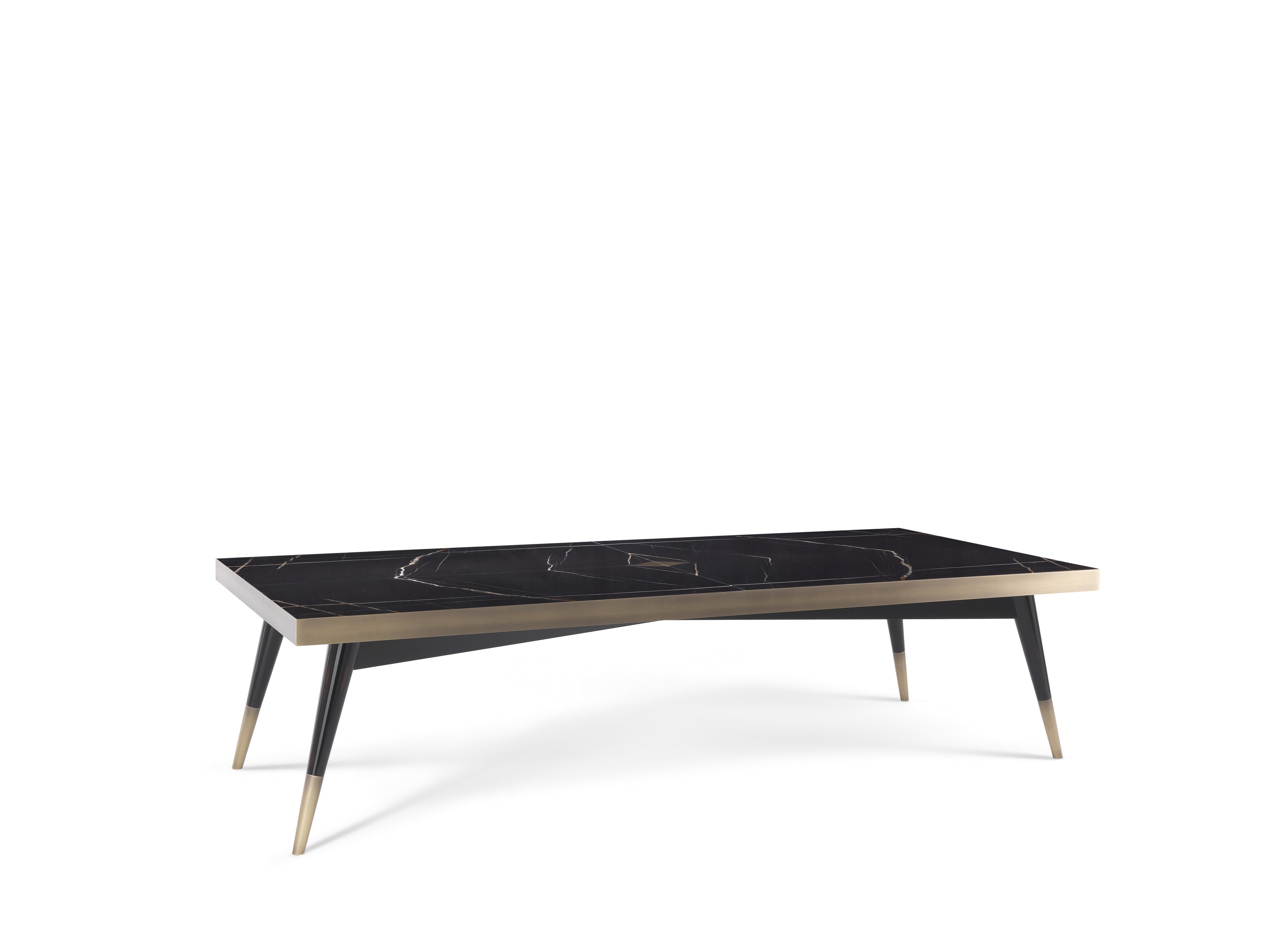 Une nouvelle version de la table à manger Mayfair a été présentée cette année avec une forme rectangulaire. Le plateau en marbre précieux Sahara Noir présente un losange central en laiton d'où part la subdivision du marbre en miroir. Les pieds fins,