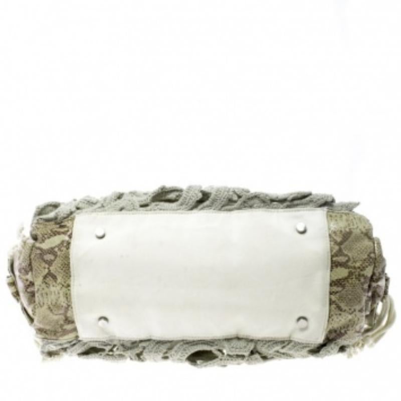 Aggiungi un tocco di charme alla tua collezione con questa tote chic e decorata di Gianfranco Ferrè. Con dettagli all'uncinetto e finiture in pelle con stampa pitonata, la tote ha interni foderati in tessuto e chiusura con coulisse. Grazie allo