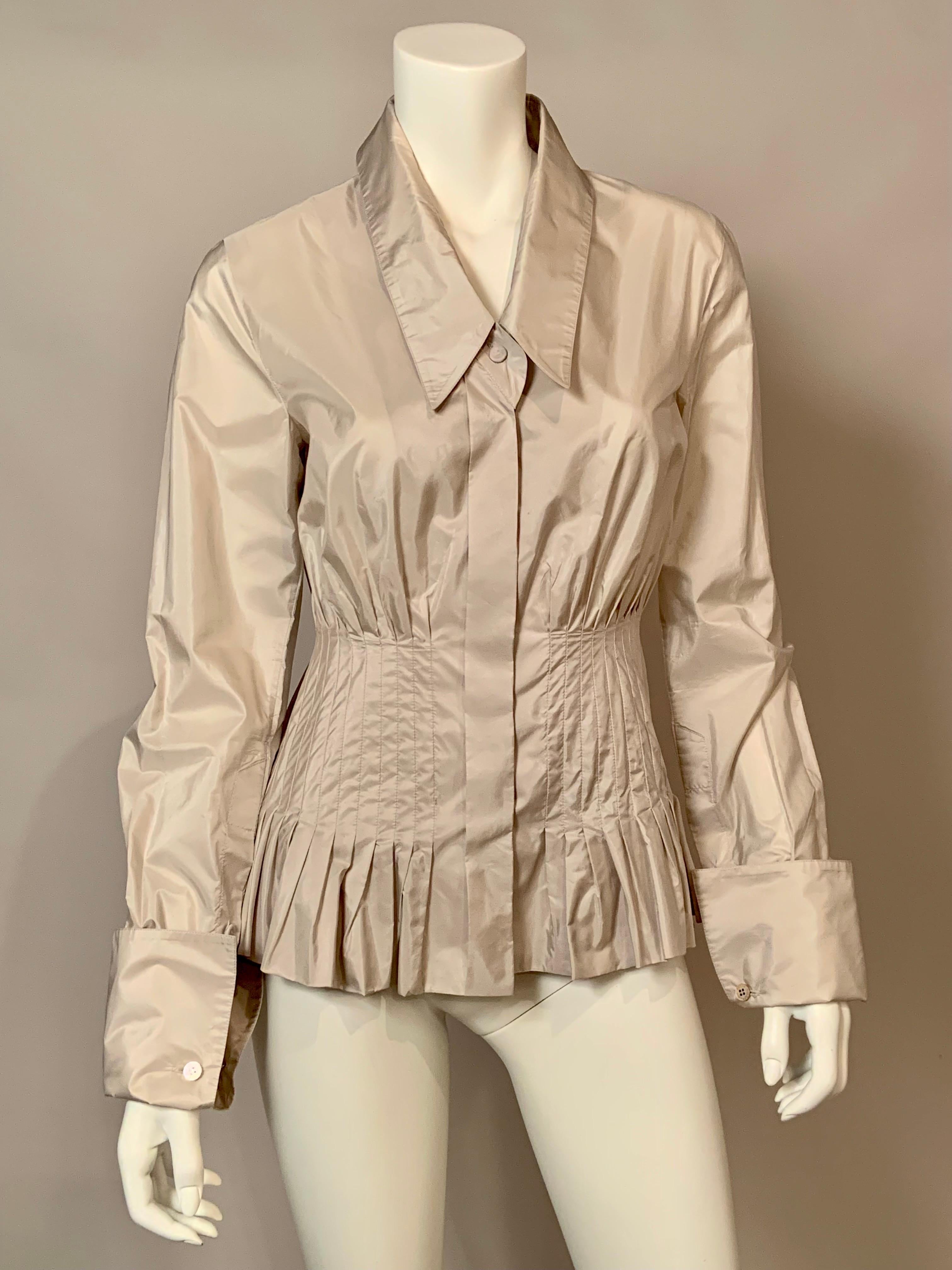 Gianfranco Ferre Designed this pale oyster grey silk blouse  with some interesting details. The button front blouse has a pointed collar, hidden buttons, long sleeves  with French cuffs and cufflinks and a pin tucked waistline with a peplum below. 