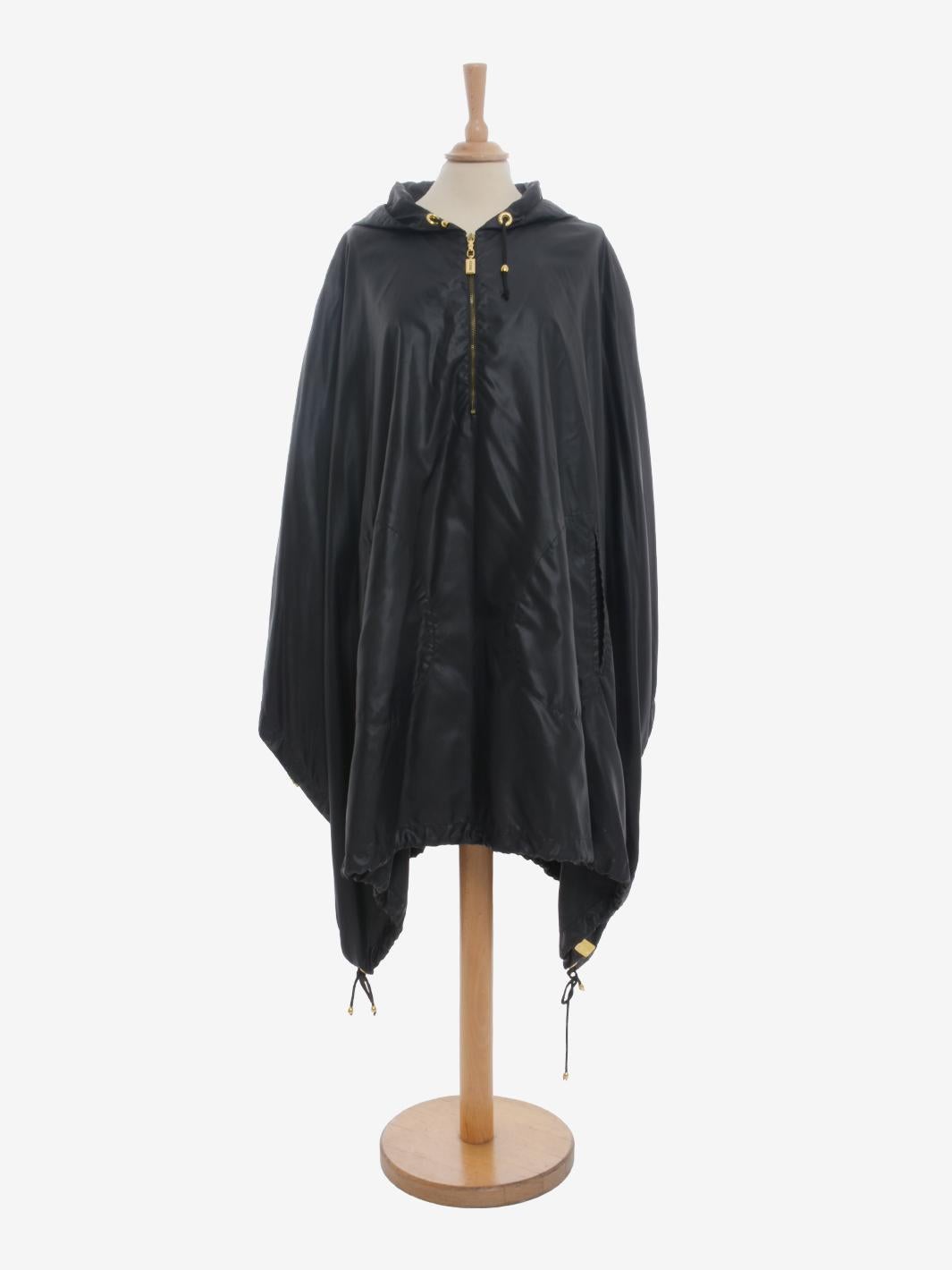 Gianfranco Ferré Raincoat is a rare outerwear from Ferré featuring a wide cape-style structure with side zipper openings and contrasting red interior piping. Each zipper and gold metallic detail is embellished with the brand's logo. Iconic garment