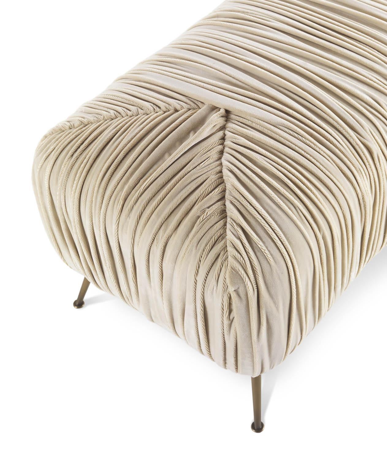 Versatile and original, Rowe pouf has brass feet which recall the 1950s and a special pleated padding with an original game of geometries resulting from the combination of trapezoidal shapes. The upholstery in thick velvet highlights the shapes of