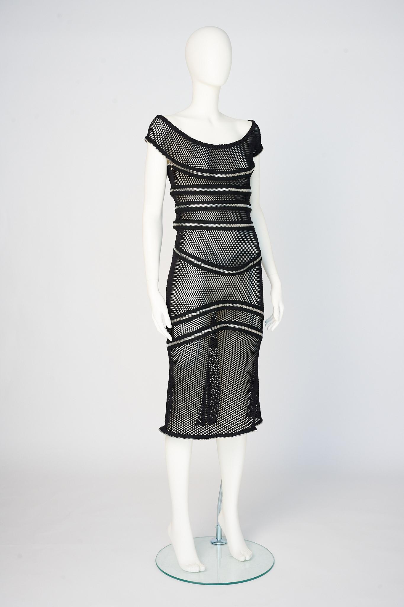 How unusual, unique and playful is this 2005 Spring-Summer Gianfranco Ferre piece !!!
Made from black fishnet, the dress is entirely detailed with silver metal zip fasteners ! On the catwalk, it was styled with a contrasting white tank dress