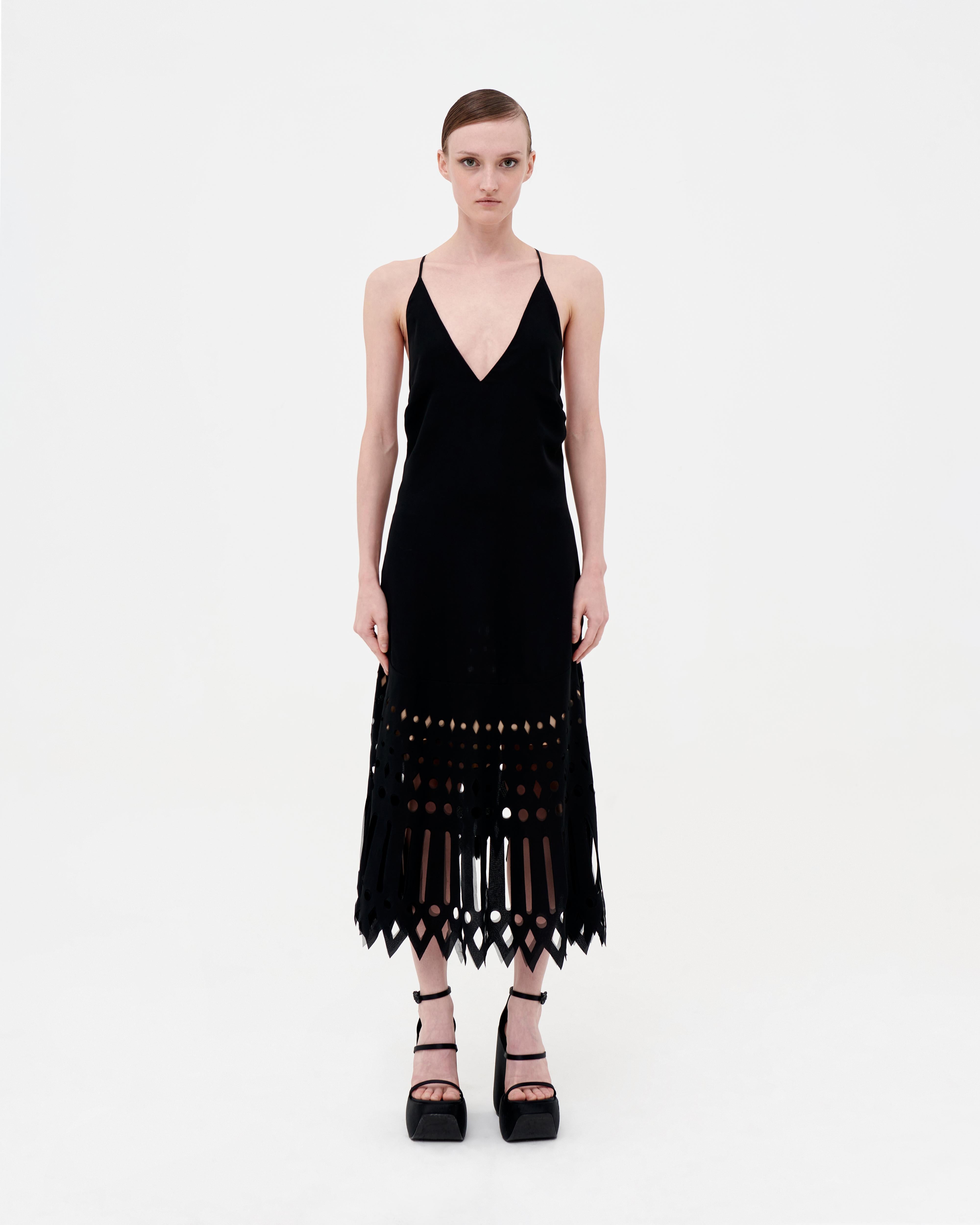 Gianfranco Ferré plunging black dress with laser cut geometrical motif. Nude petticoat from the waist on, backless with skinny shoulder straps and asymmetric flare. Minor faults on the detailing on the back, reflected on price

Size Italian