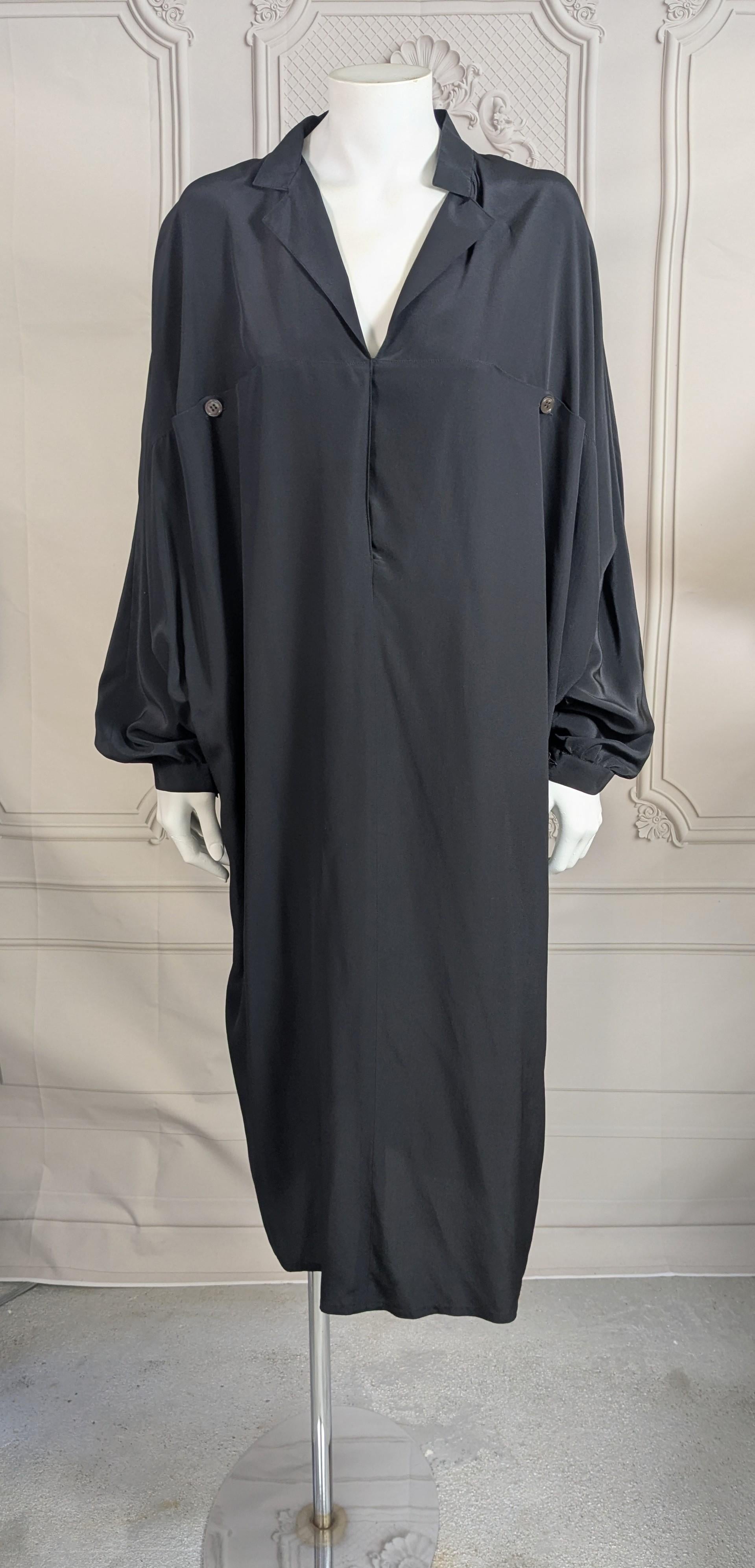 Elegant Gianfranco Ferre Silk Crepe Dolman Sleeve Dress from the 1990's. Cut like a kite, wide on top with deep dolman sleeves which taper to hem. A seam across bust has 2 decorative button pockets and a hidden button placket down center front.
