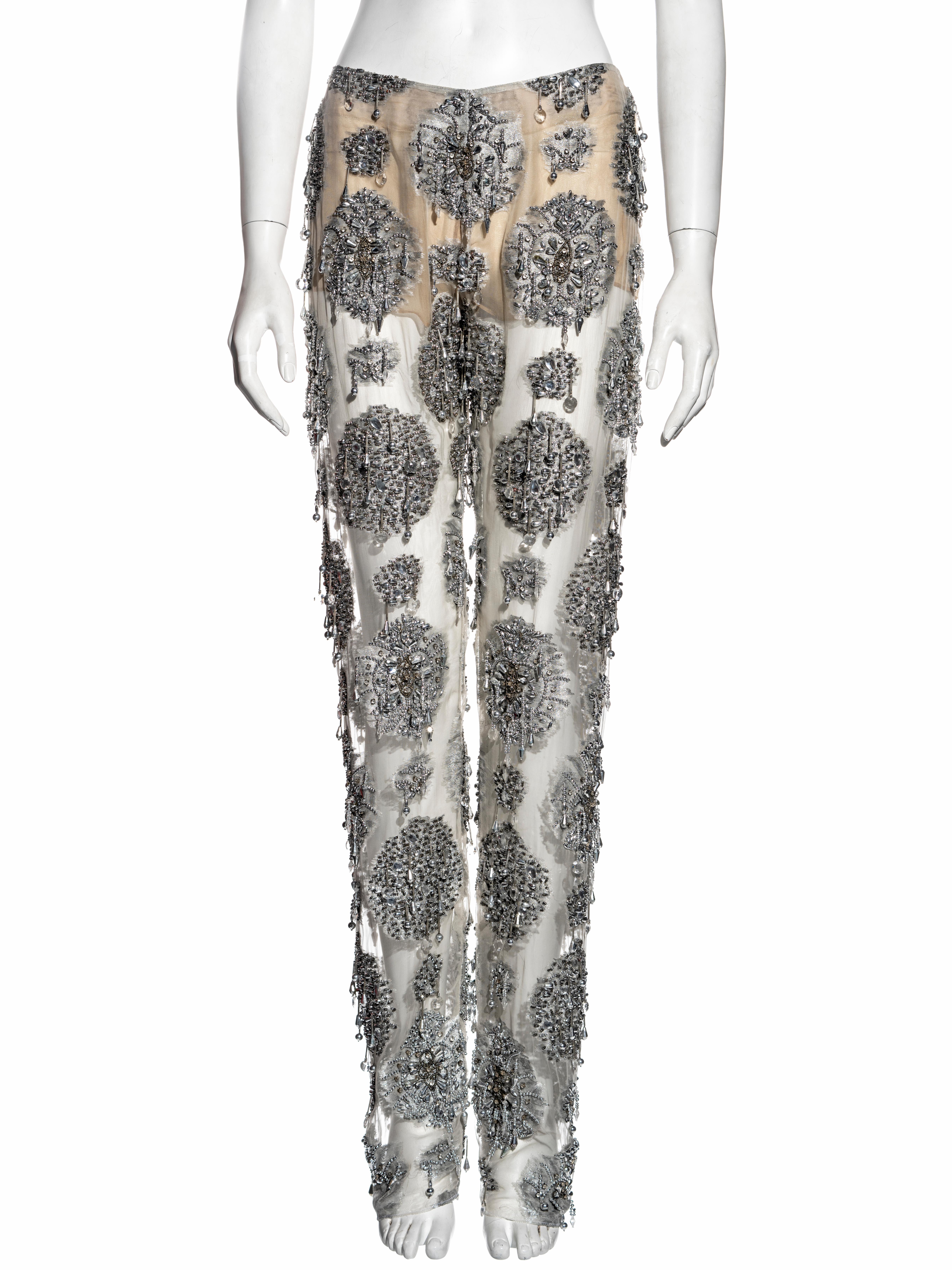 ▪ Gianfranco Ferré evening pants
▪ Metallic silver silk organza 
▪ Silver beaded tassels and embellishments 
▪ Straight leg 
▪ IT 42 - FR 38 - UK 10 - US 6
▪ Spring-Summer 2002
▪ 100% Silk
▪ Made in Italy