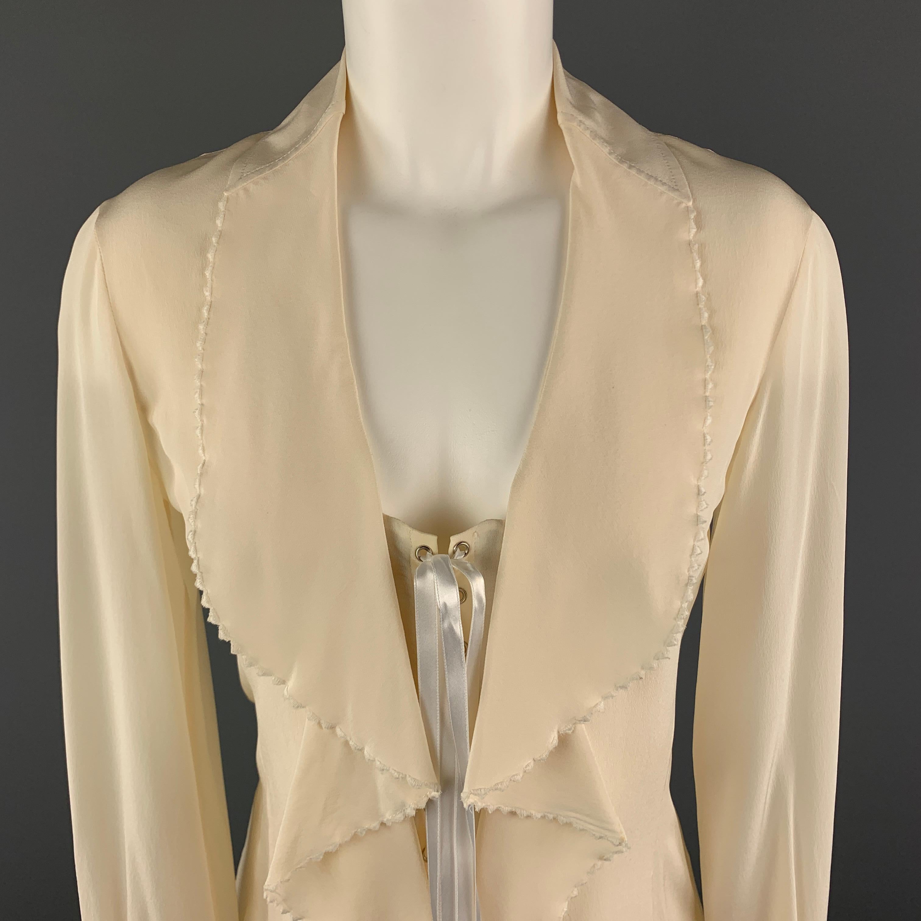 GIANFRANCO FERRE Blouse comes in a cream tone in a silk material, with a ruffled collar and front, a corset effect, long sleeves, buttoned cuffs, a side zipper, and a silver tone metal hardware. Small spots at front. Made in Italy.

Very Good