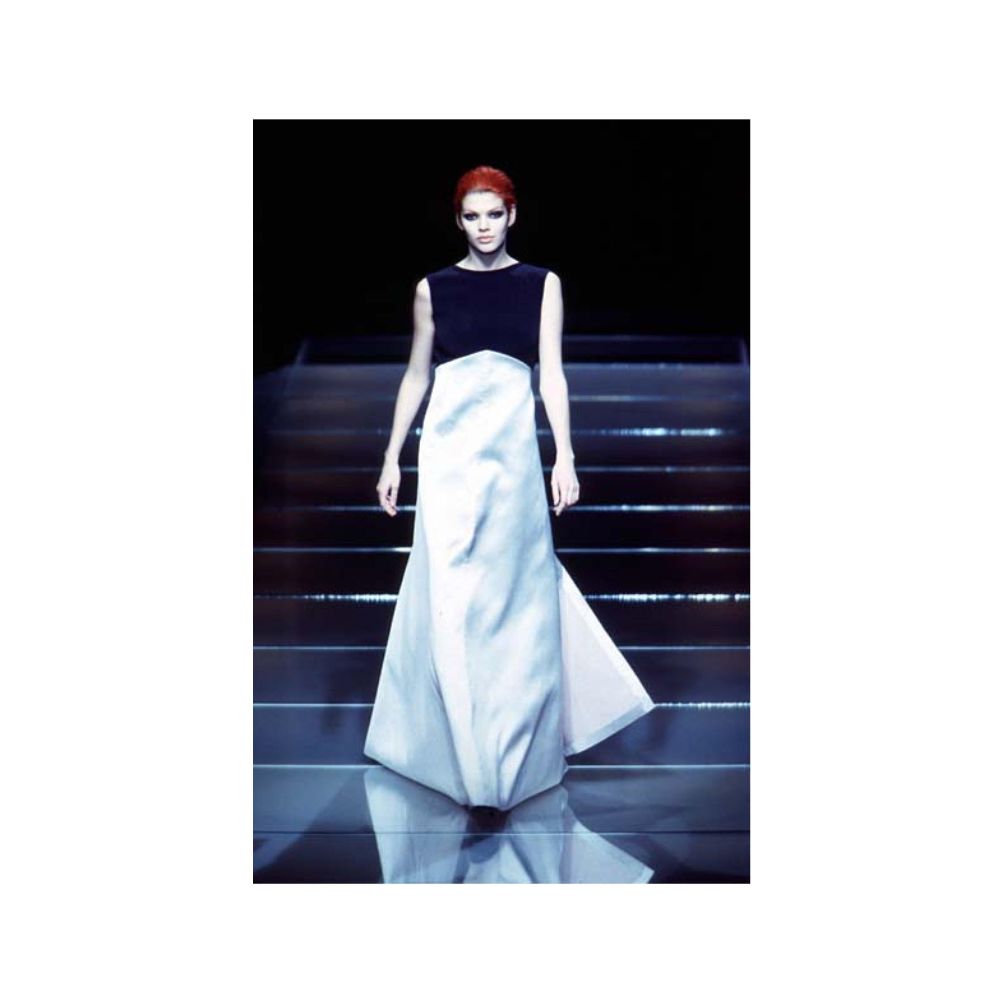 El glamour se une a la rareza en este Vestido de terciopelo y seda Gianfranco Ferré de Otoño/Invierno 1996. El tejido de seda plateada con larga cola y abertura frontal, junto con el cuello barco de terciopelo negro y la espalda abierta, destilan