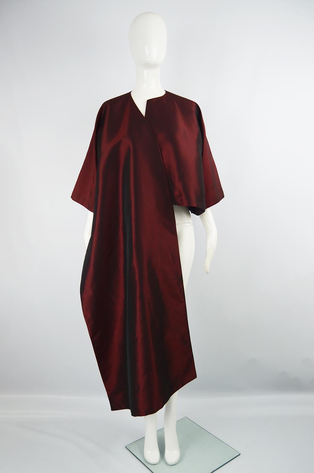 A sculptural vintage Gianfranco Ferre evening jacket from the 90s. In a red taffeta with an asymmetrical, open front design and short sleeves, creating a look that is perfect for layering or at a formal party. 

Size: Marked IT 42 but one size fits