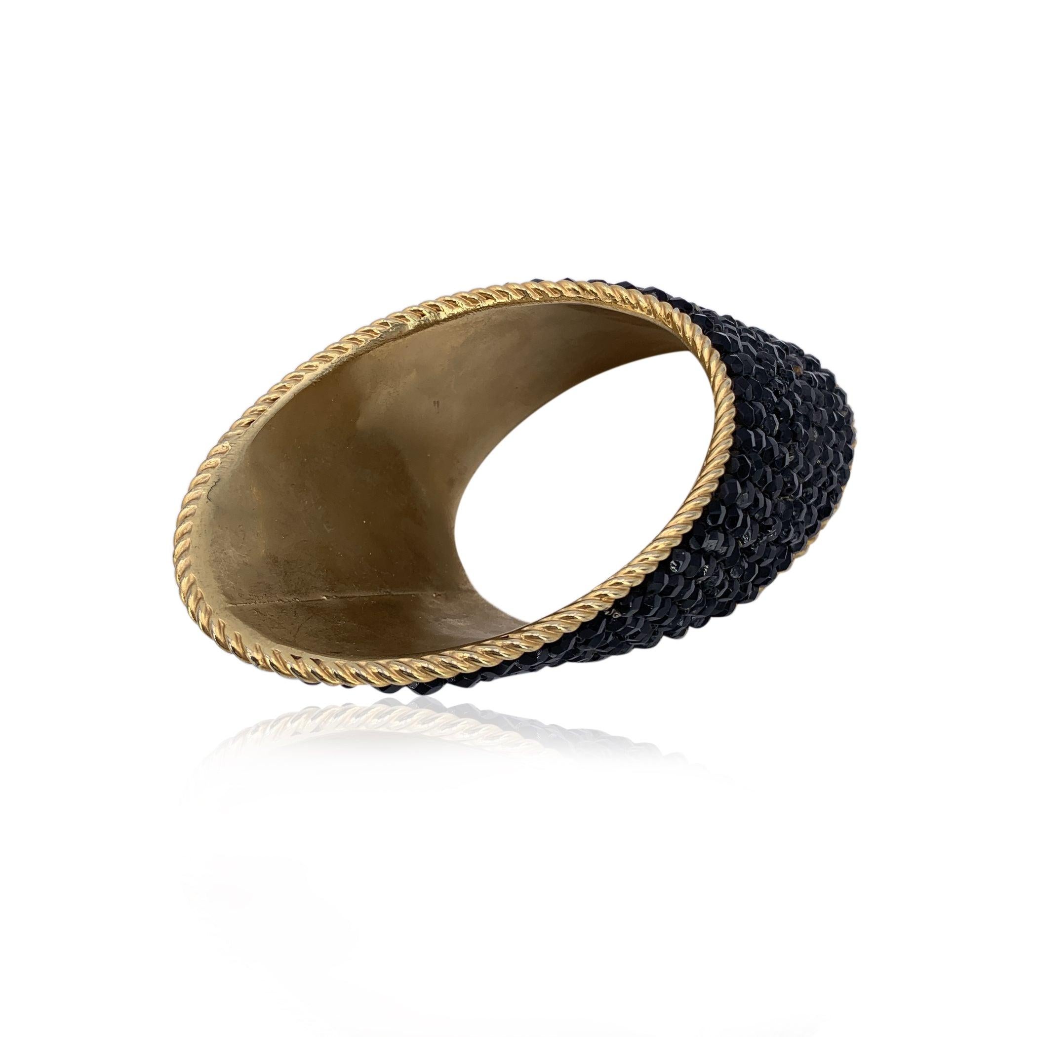 Step back in time with this stunning vintage '80s bangle bracelet, signed by the iconic Gianfranco Ferre. The cylindrical shape of the bracelet is elegantly enhanced by the oblique cut of its ends, adding a unique twist to its classic design. The
