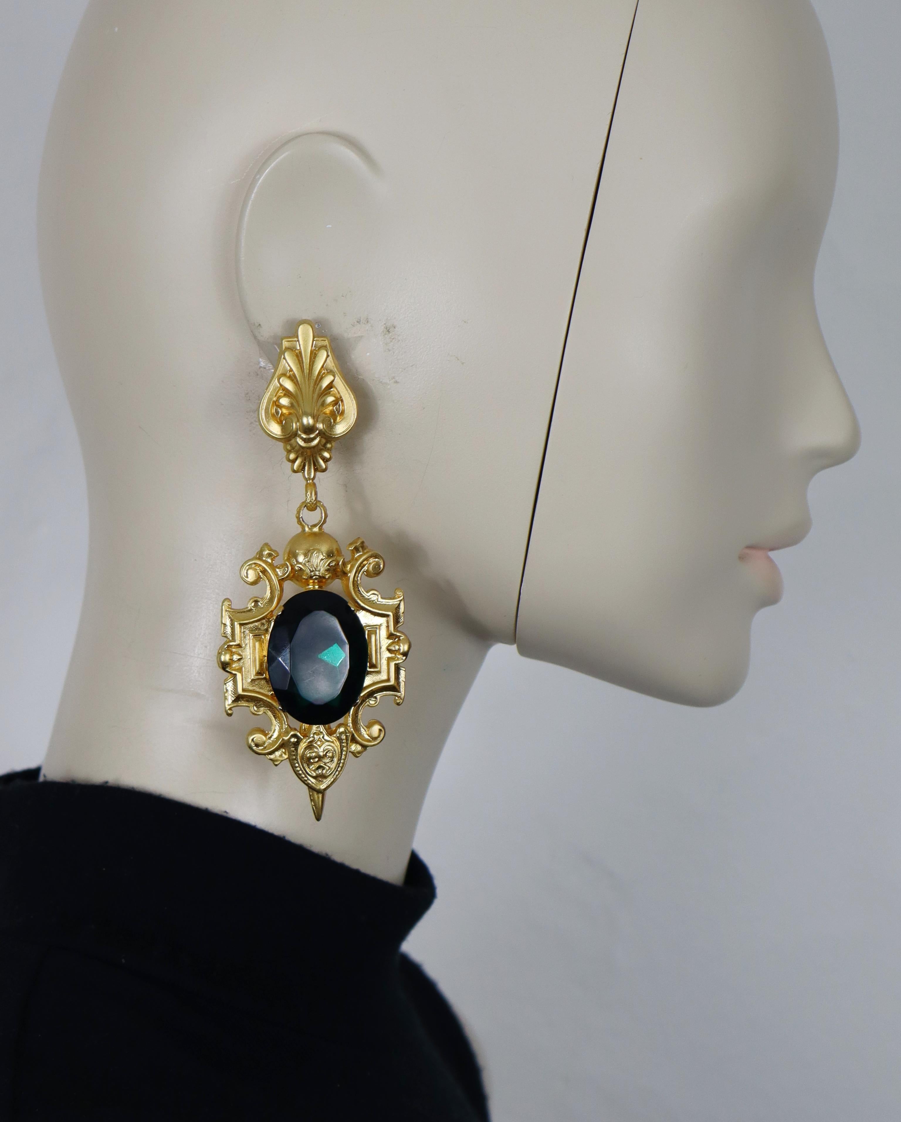Pendientes colgantes GIANFRANCO FERRE vintage en tono dorado macizo (de clip) adornados con un gran cristal verde ovalado.

Estampado FERRE Fabricado en Italia.

Medidas orientativas: altura aprox. 11 cm / anchura máx. aprox. 4,3 cm.

Peso por