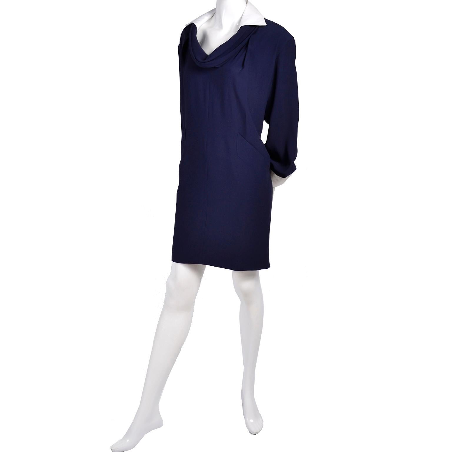 This is a great vintage 1990's Ferre Studio 0001 dress that is super versatile and easy to wear. The dress is in a navy blue rayon blend with a white pique collar and upturned cuffs.  The neckline is so  beautifully draped and we like the way the