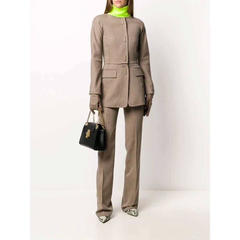 Gianfranco Ferrè wool dove-grey 90s suit composed by jacket and trousers. Fitted double-breasted jacket with round neckline, detachable zipped bottom, long sleeves with zipped cuffs and gloves. Frontal faux welt pocket with flap. Frontal hooks