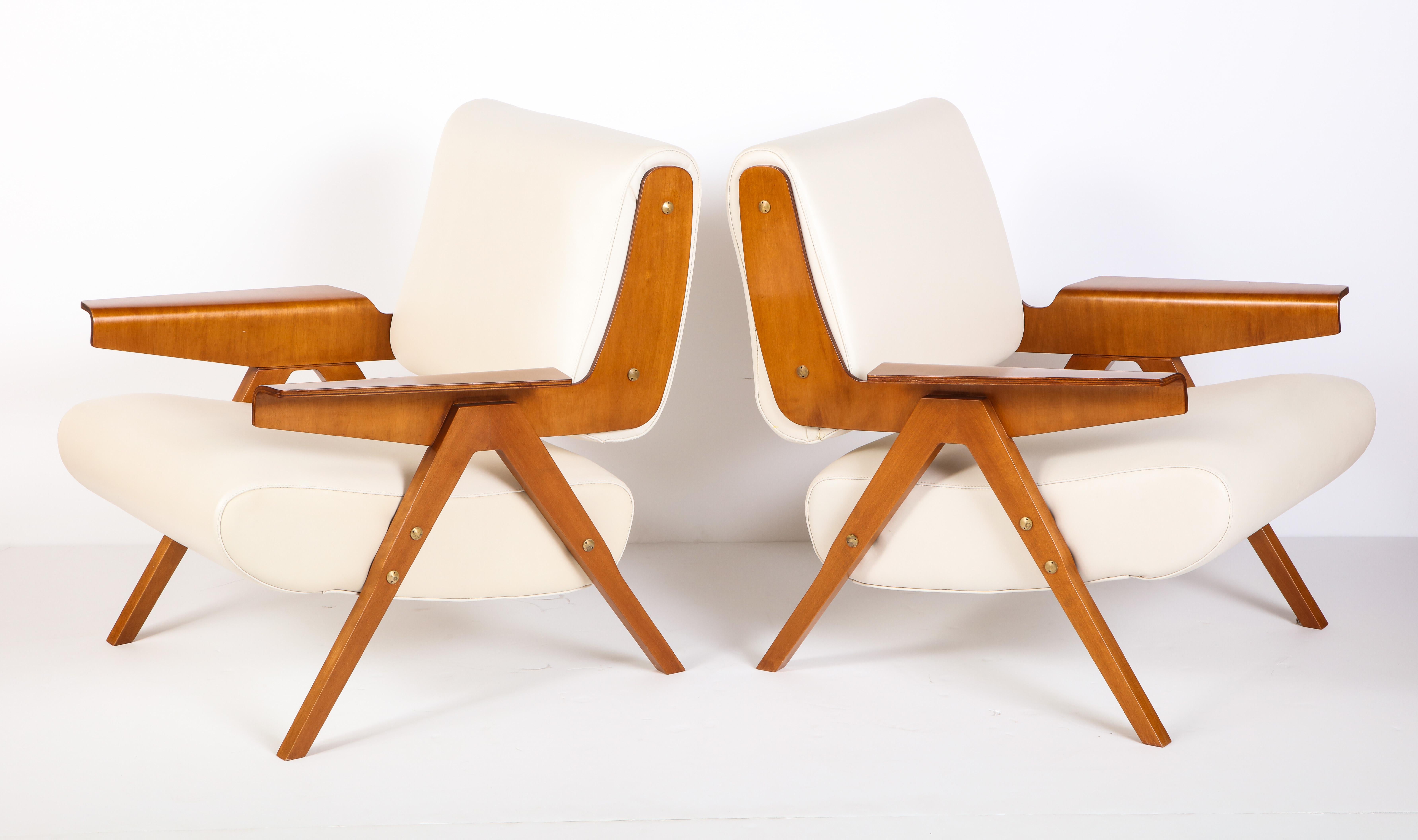 An exceptionally rare and fabulous pair of lounge chairs by Gianfranco Frattini. The bent plywood and angular legs make these very distinctive chairs.