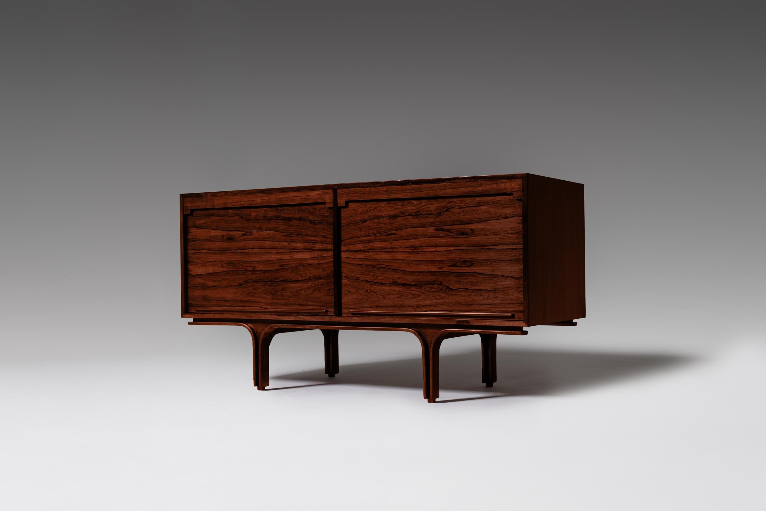 Rosewood sideboard by Gianfranco Frattini for Bernini, Italy, 1960s. An elegant piece equipped with tambour sliding doors which are typical for Frattini’s work. The top of the cabinet rest on almost sculptural like bentwood base with upstanding