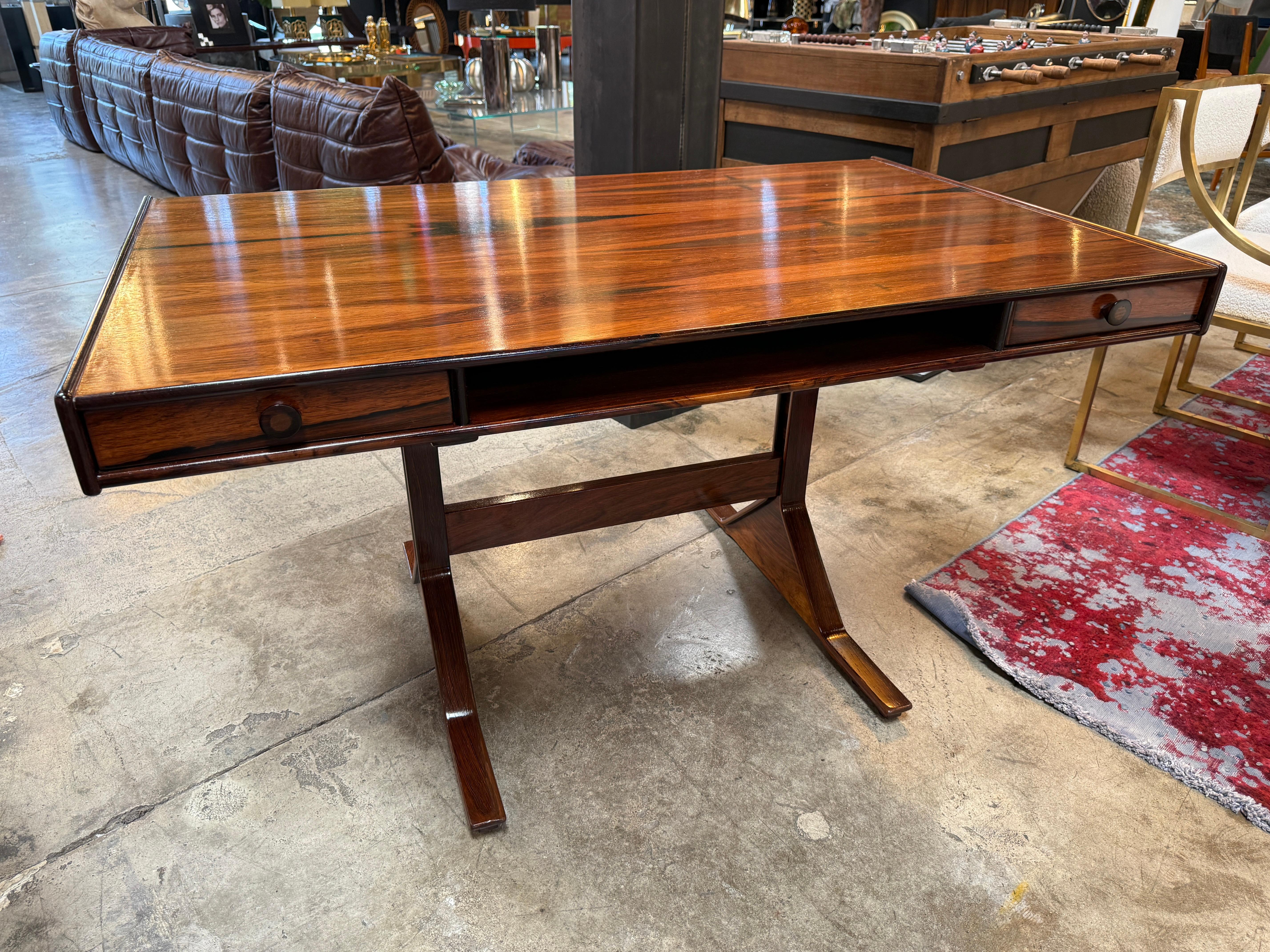 This elegant desk, designed by Gianfranco Frattini in 1956 for Bernini, radiates the quiet sophistication of mid-century Italian design. Its rich, polished wood surface exudes warmth and depth, with a natural grain that draws the eye and adds a