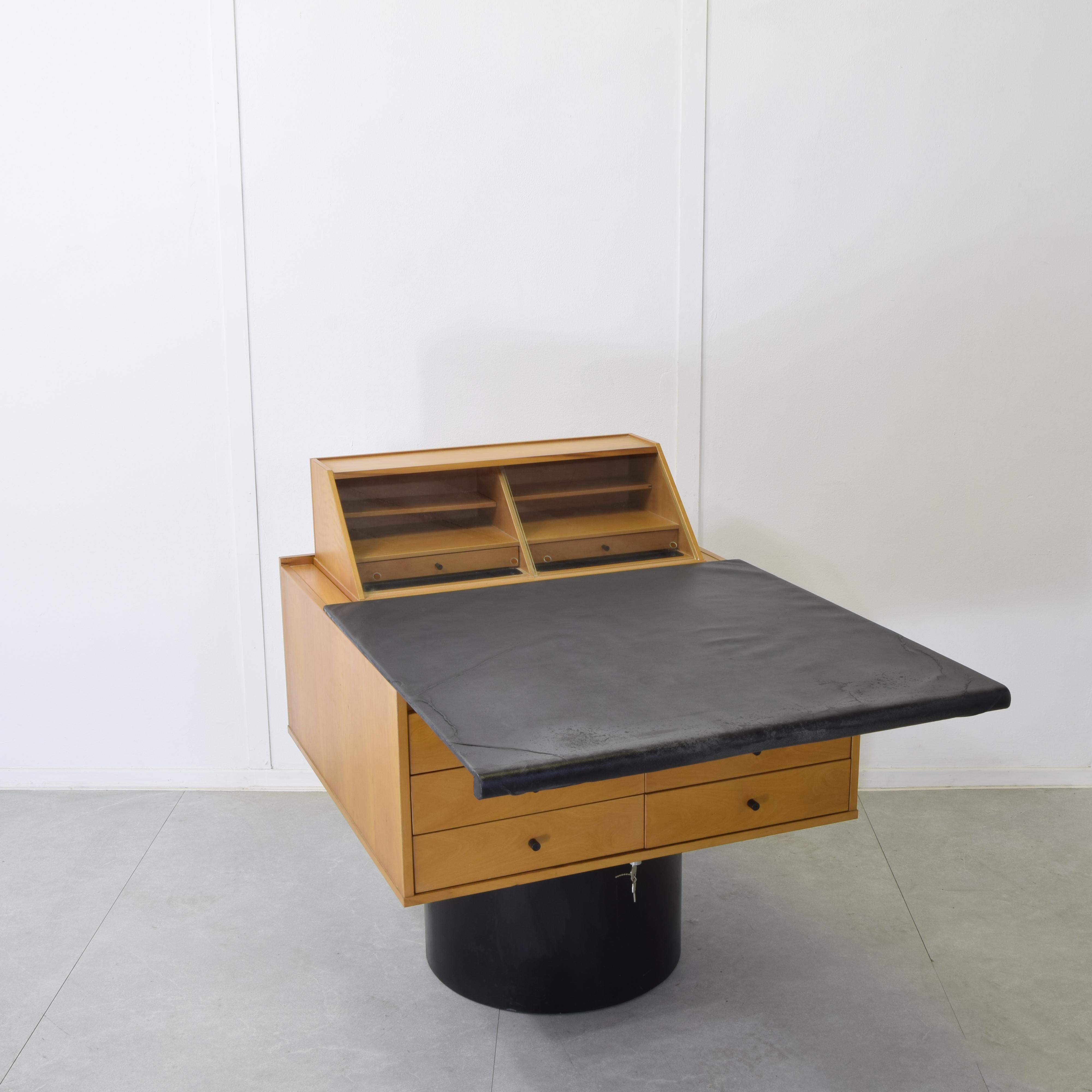 Raro scrittoio modello Sesamo 841 disegnato da Gianfranco Frattini per la produzione Bernini circa 1982. Struttura portante circolare in ferro laccato nero piano in pregiata pelle nera pieghevole cassetti e struttura in legno di faggio chiaro.

Lo