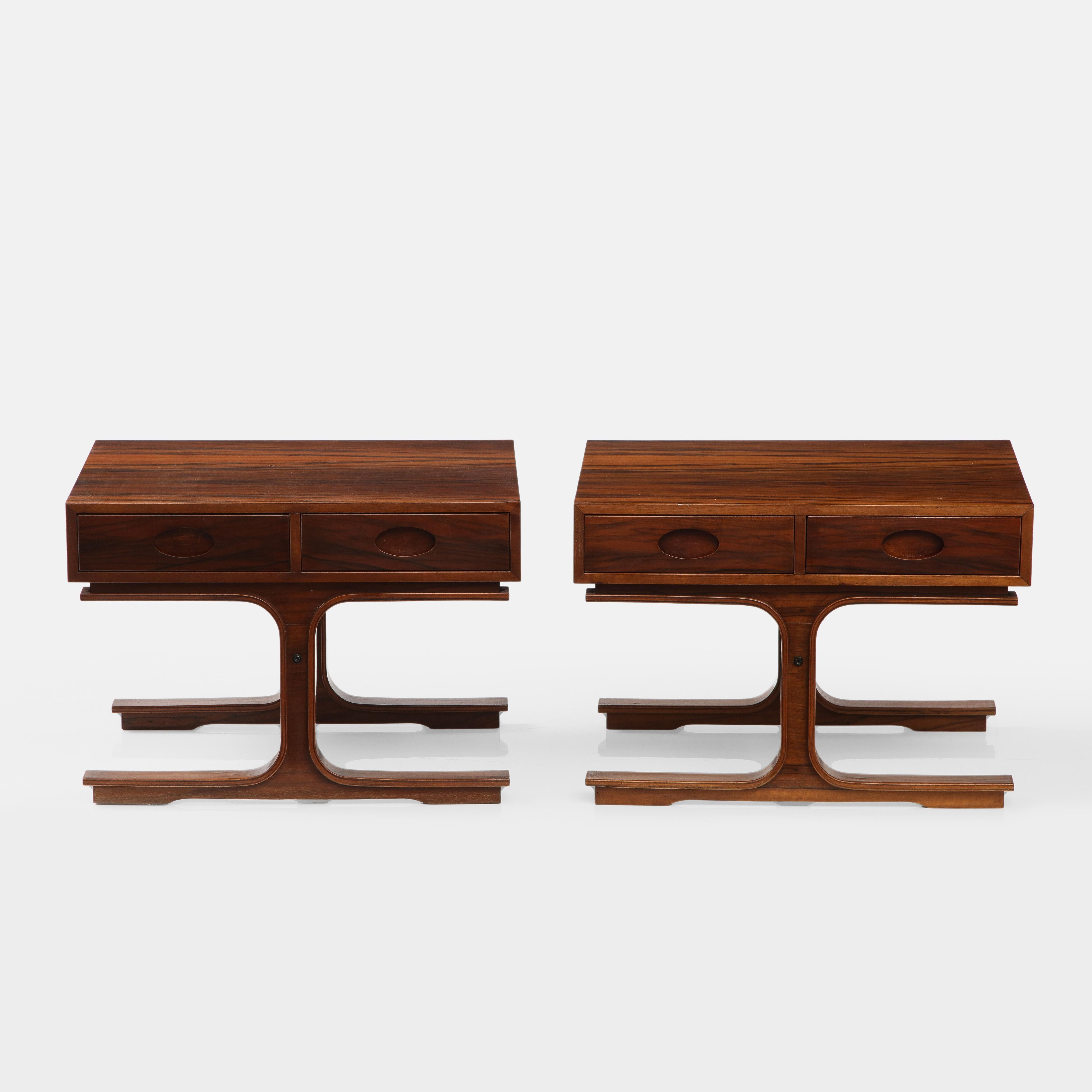 Gianfranco Frattini for Bernini modernist pair of side or bedside tables model 554 in rosewood each with two drawers and central front and back legs. These chic architectural tables have typical Bernini design elements including cutout oval drawer