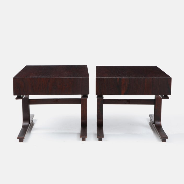 Gianfranco Frattini for Bernini modernist pair of side or bedside tables model 554 in rosewood each with two drawers and central front and back legs. These chic architectural tables have typical Bernini design elements including cutout oval drawer