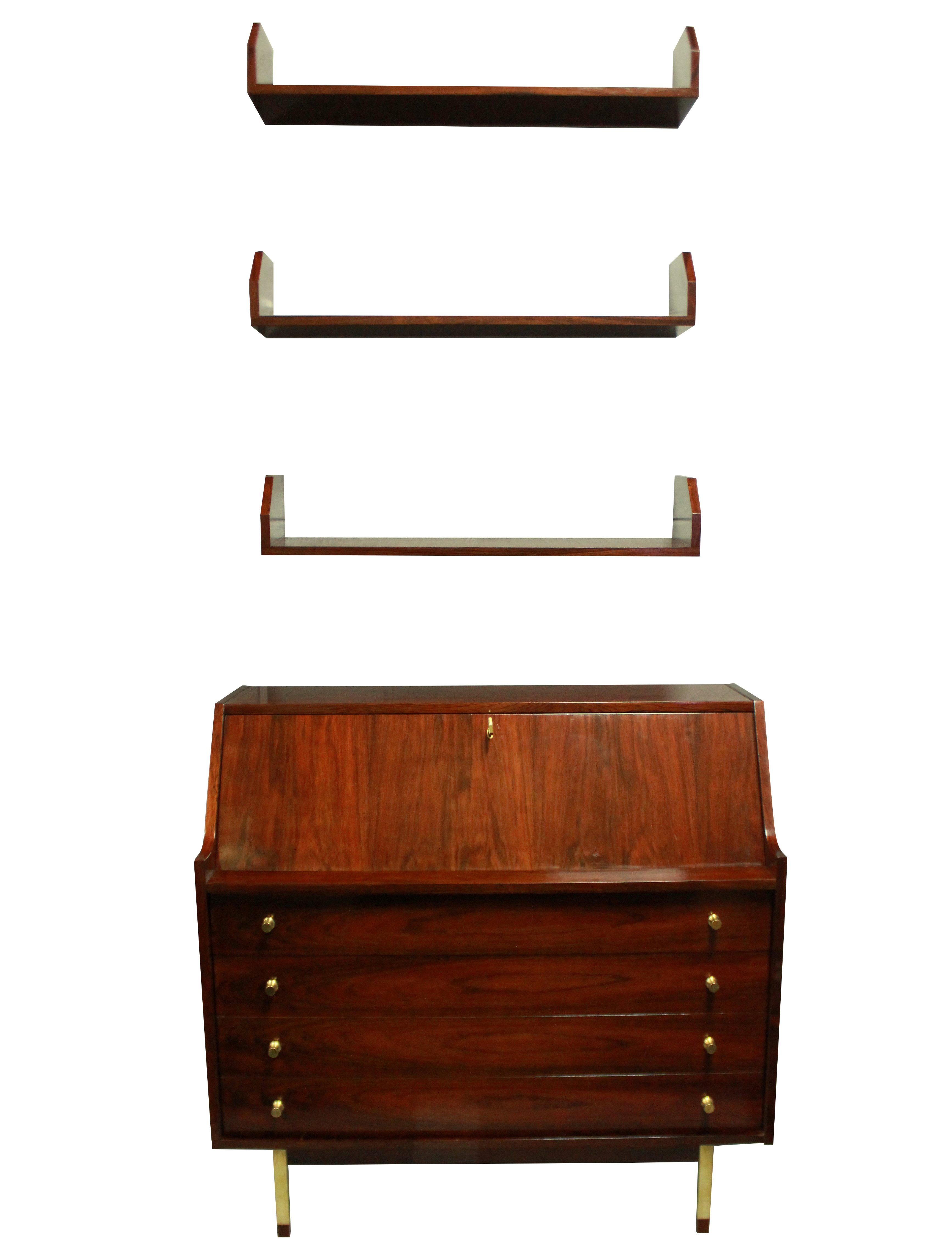 An Italian secrétaire with three wall shelves by Gianfranco Frattini for Bernini. In rosewood veneer, with brass handles and key and brushed gold legs.