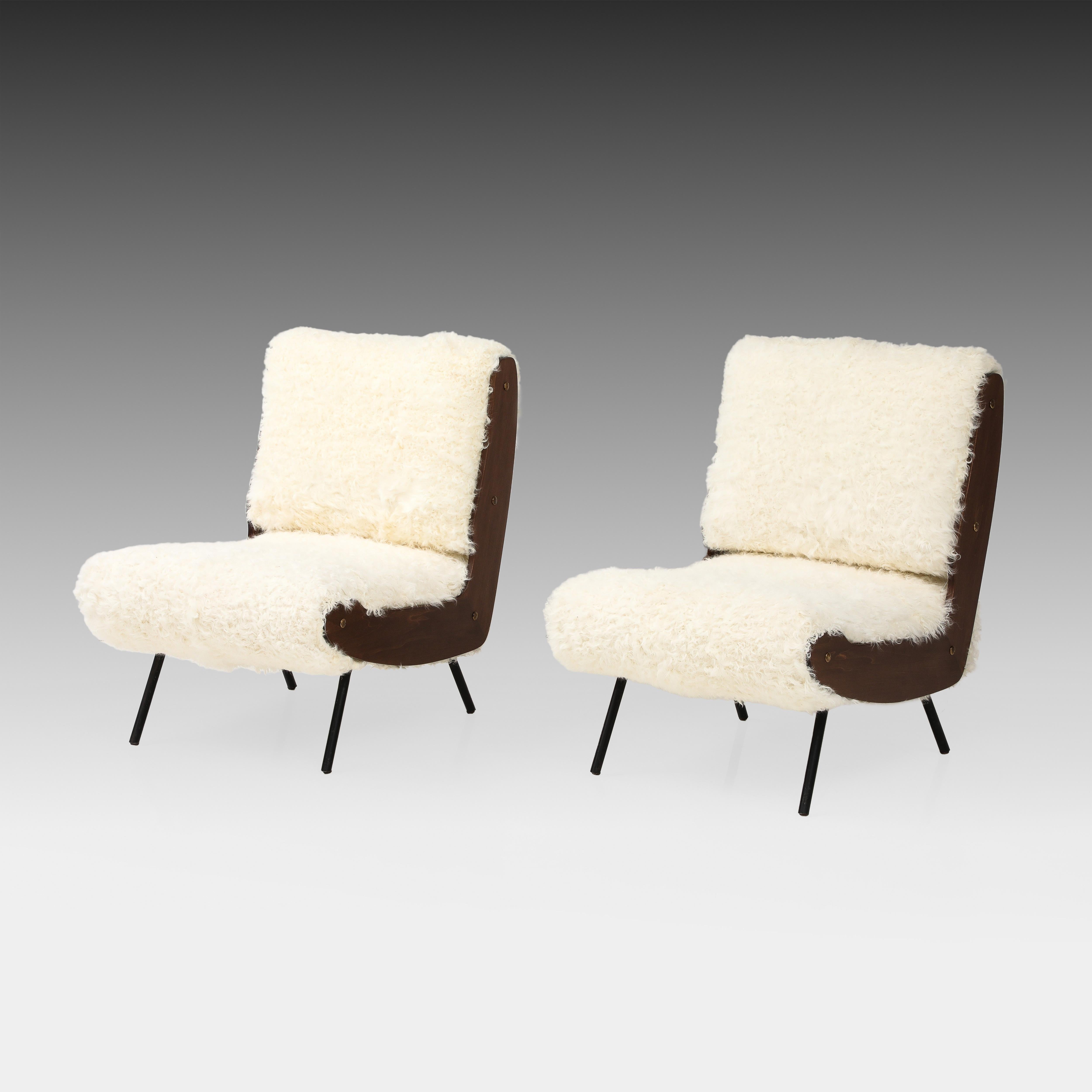 Gianfranco Frattini for Cassina rare pair of lounge chairs model 836 with walnut frames, black painted tubular metal legs, and back and seat cushions upholstered in a luxurious ivory or natural Kalgan lambskin or lamb fur.  These chic and iconic low