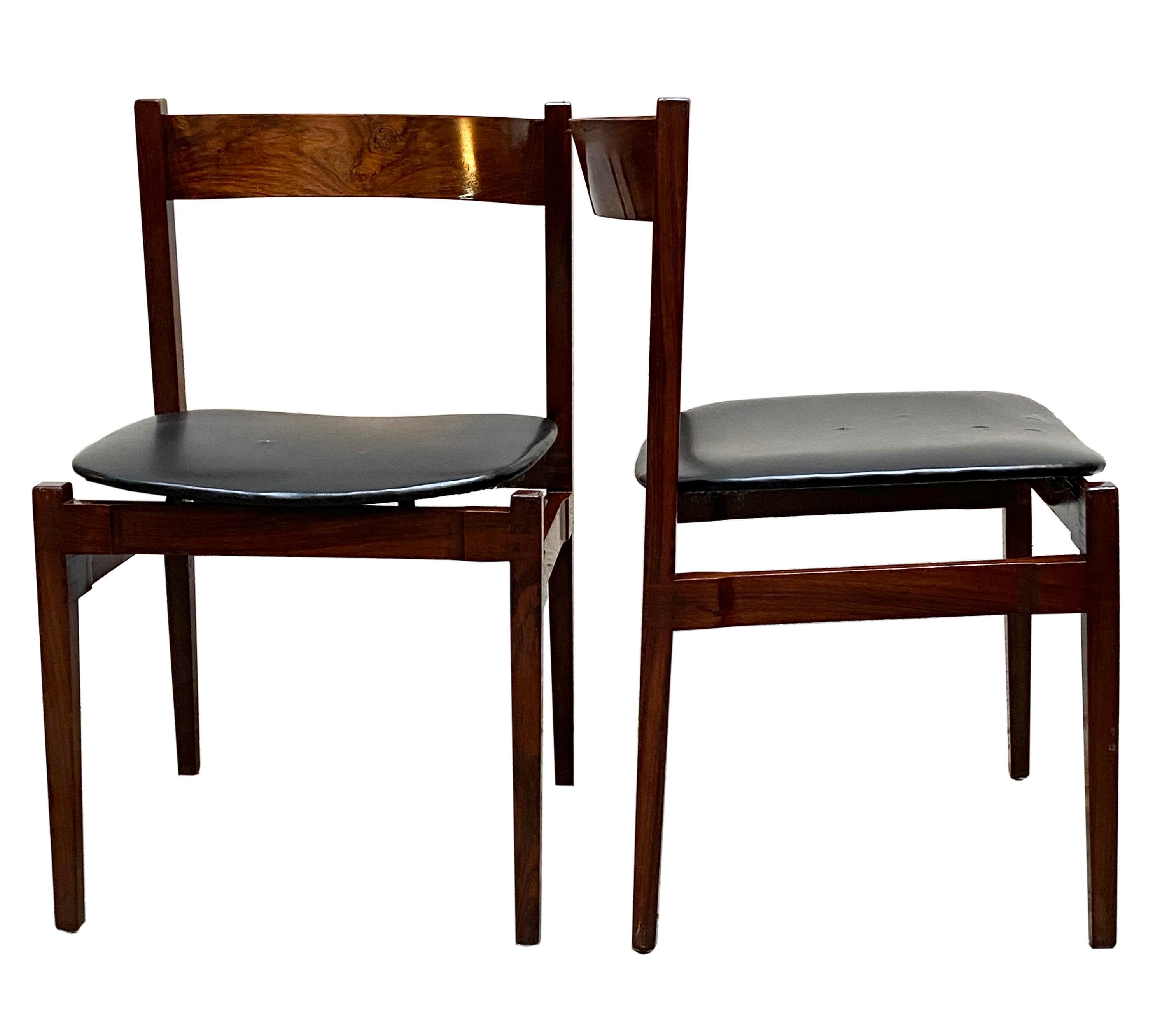 Pair of iconic chairs in wood and leather model 101 designed by Gianfranco Frattini for Cassina.
The frame has linear shapes and a rounded back.
The original black leather seat shows signs of wear. 
Lit. G.Gramigna, Il Repertorio del Design