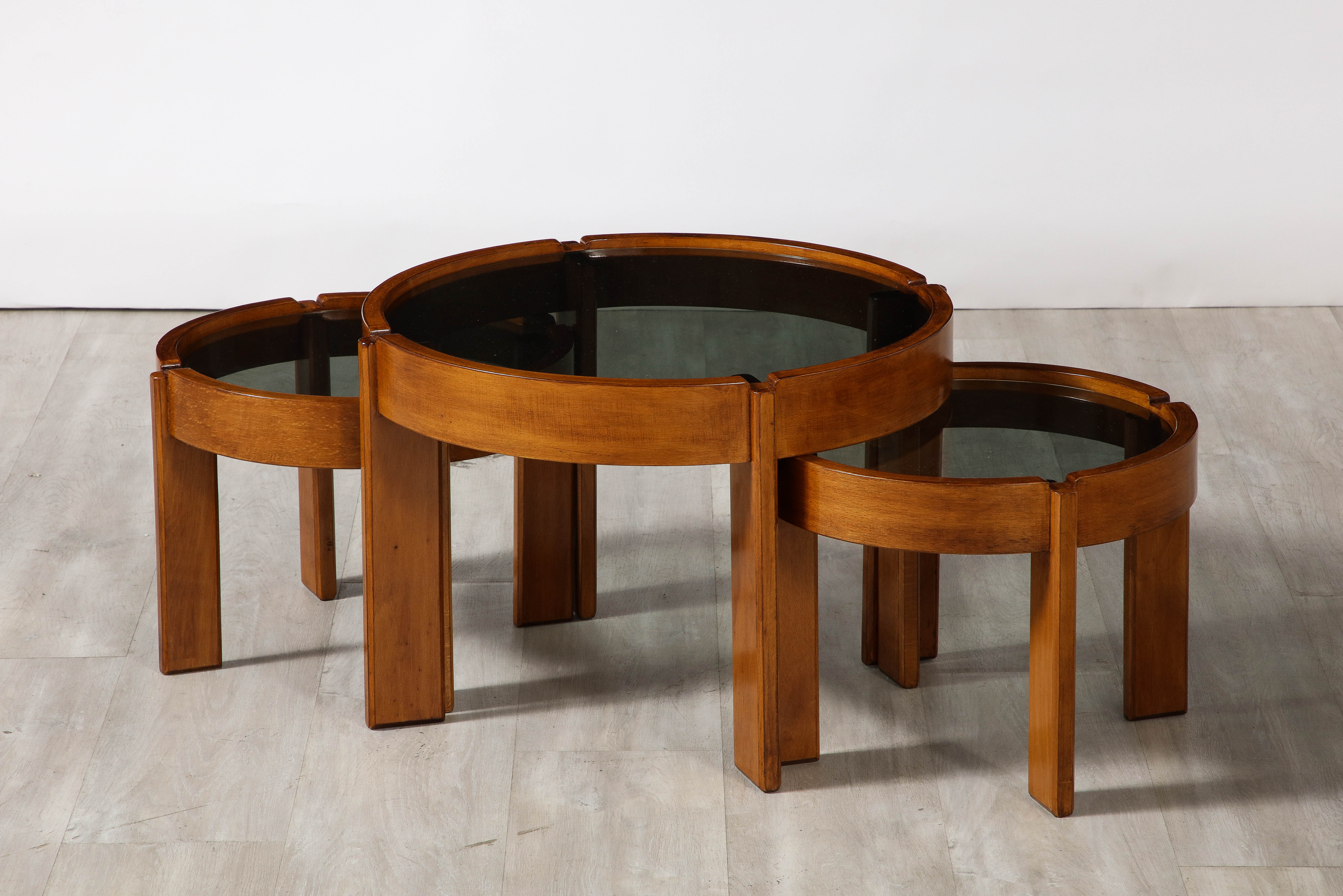 A set of three side/end /coffee tables designed by Gianfranco Frattini for Cassina, late 1960's. Beautiful angled walnut legs with inset smoked glass circular tops. 

By Gianfranco Frattini for Cassina, circa 1967
Size: 15