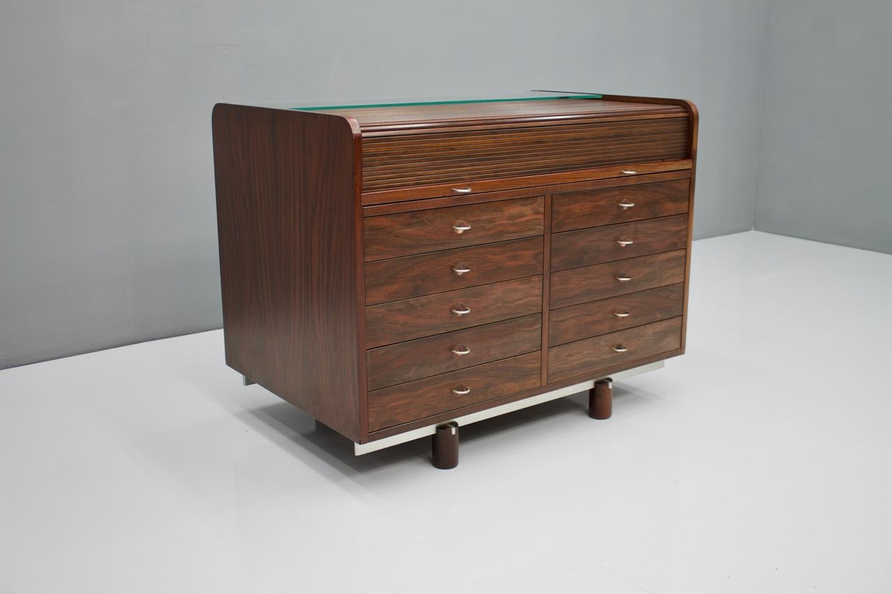 Gianfranco Frattini Mahogany secretary with roll top, Bernini, Italy, 1961.

A total of 10 drawers on the front side, free compartments at the back. The secretary can be placed freely in the room. The roll top opens by pulling out the leather