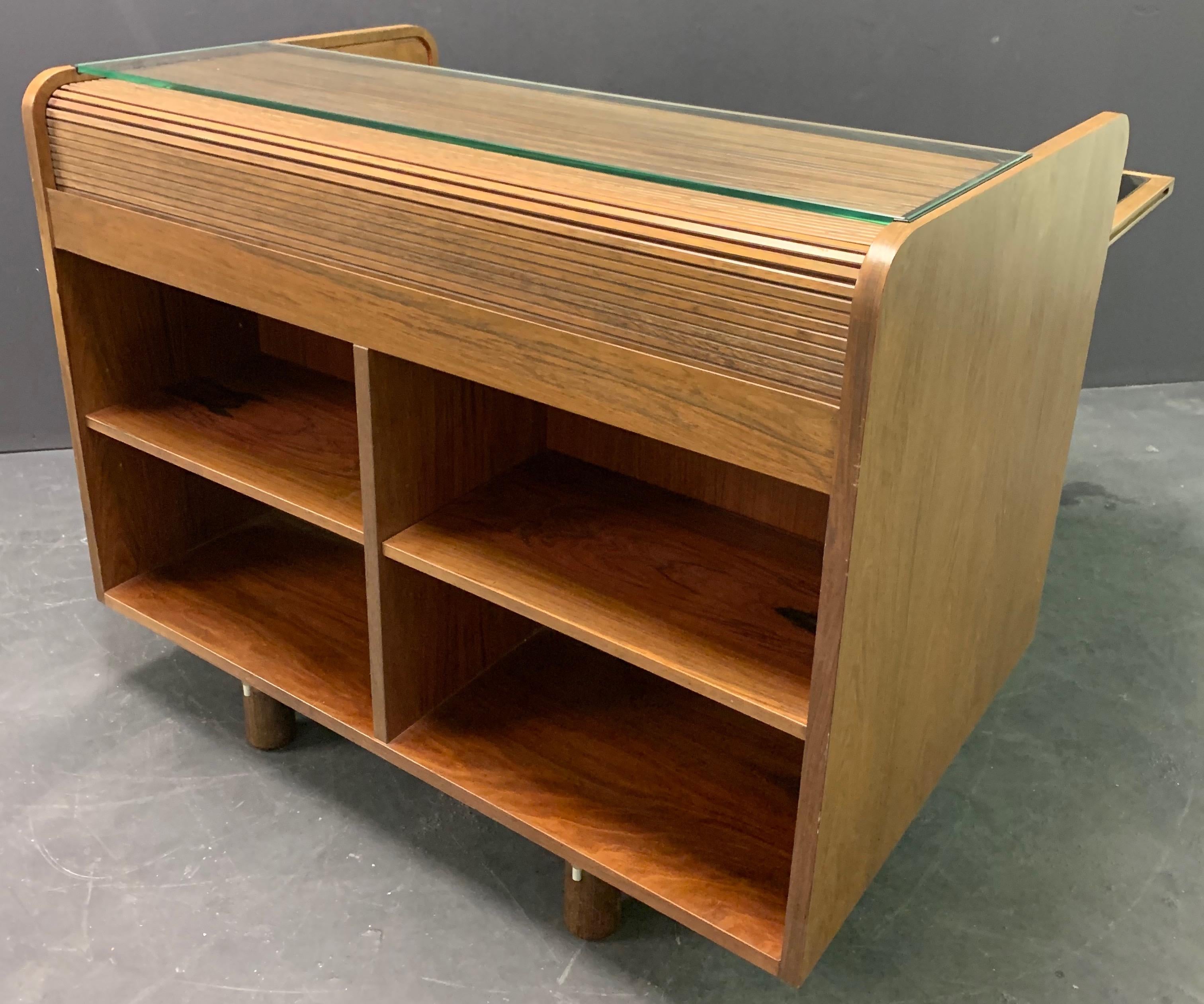 Walnut, leather an aluminum. The secretary is a practical piece of furniture as it offers plenty of storage space. On the front side there are ten large drawers. A writing surface can be pulled out that opens the secretary. A writing section above