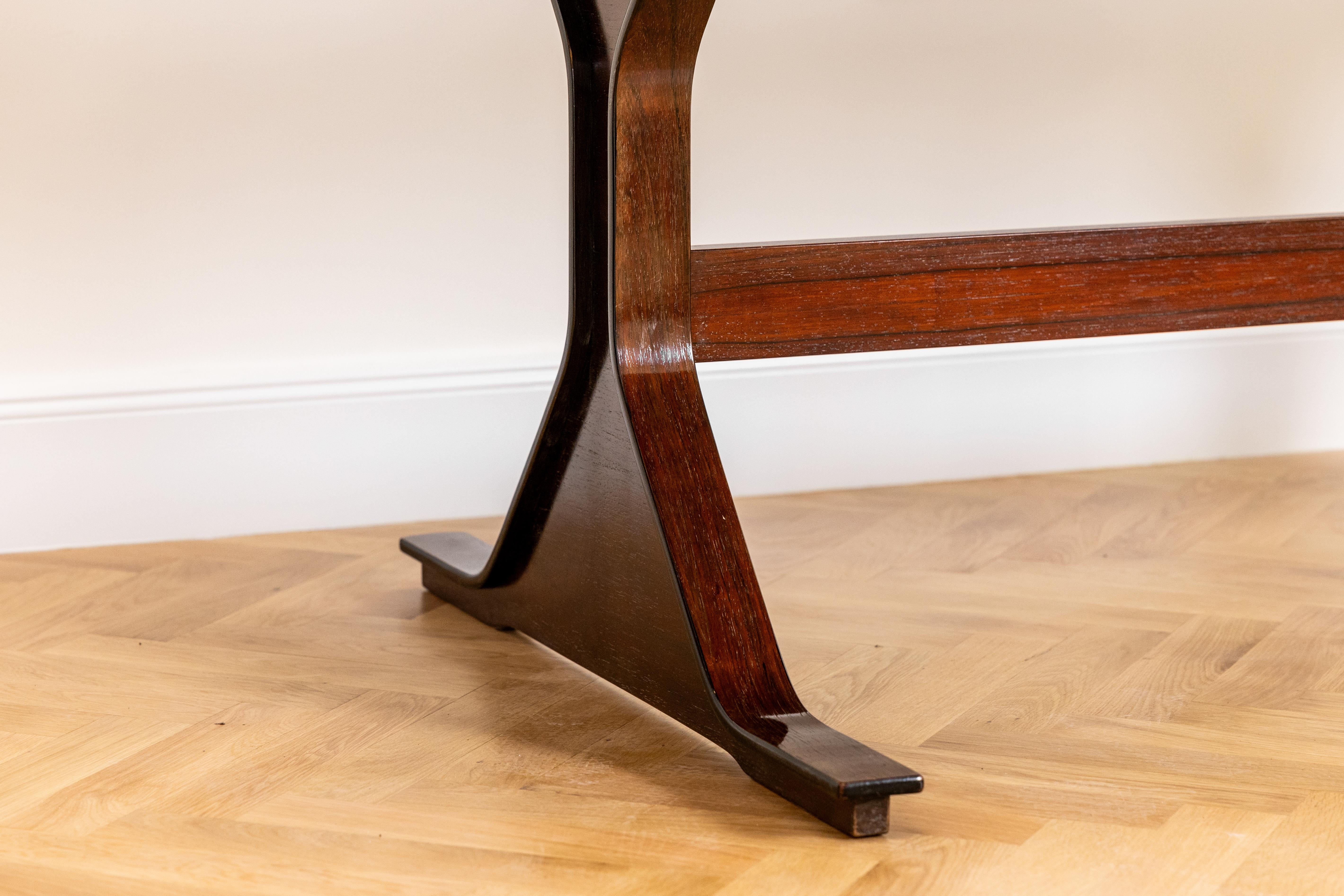 Conçue par Gianfranco Frattini pour Bernini dans les années 1960, cette table de salle à manger modèle 522 en palissandre massif illustre la précision sculpturale et le luxe des matériaux qui définissent l'âge d'or du design moderne italien.

Les