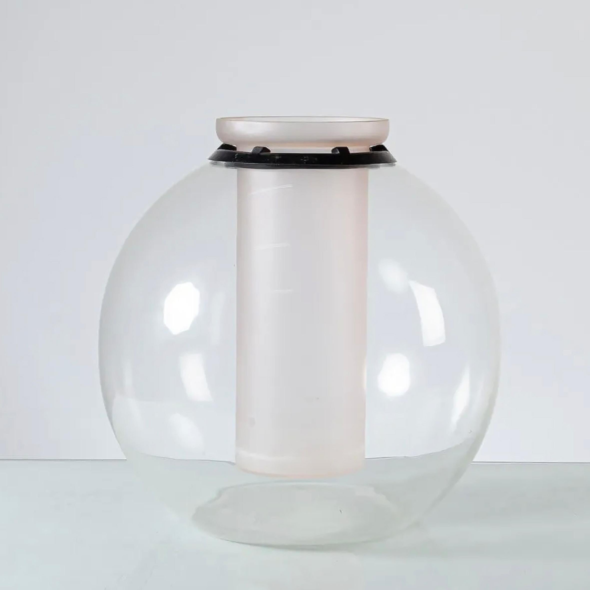 Gianfranco Frattini (1926-2004)

Sfera

Eine Vase aus Glas und Kristall.
Die kugelförmige Vase aus klarem Kristall ist mit einem Blumenbehälter aus Milchglas versehen, der von einem schwarzen Gummiring geschützt wird. 
Hergestellt von Progetti,