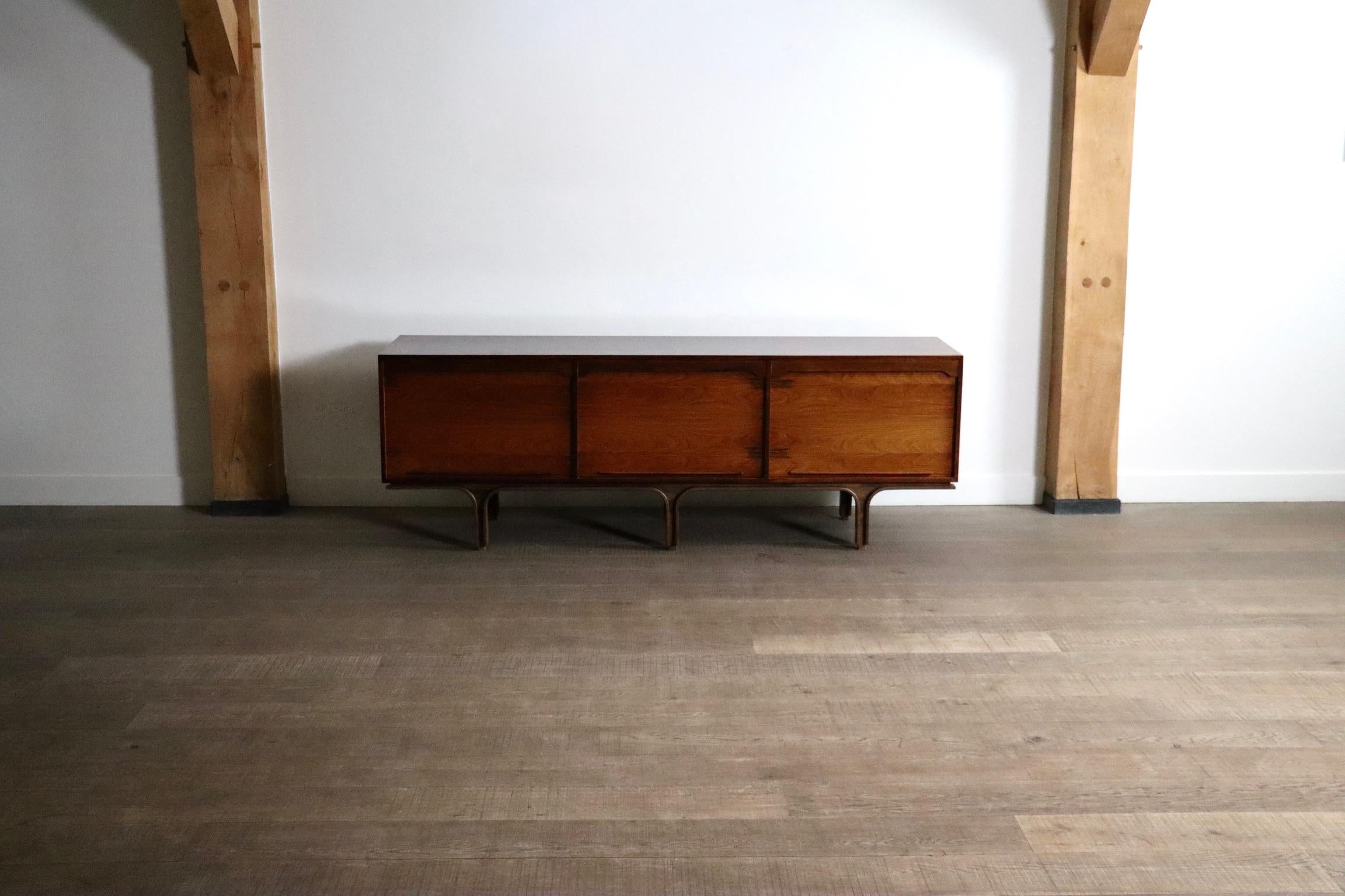 Splendida credenza di Gianfranco Frattini per Bernini, Italia anni Settanta.

Un pezzo senza tempo che combina forma e funzione e che presenta dettagli sorprendenti sia per la forma che per la finitura delle venature del palissandro.
Le tre ante