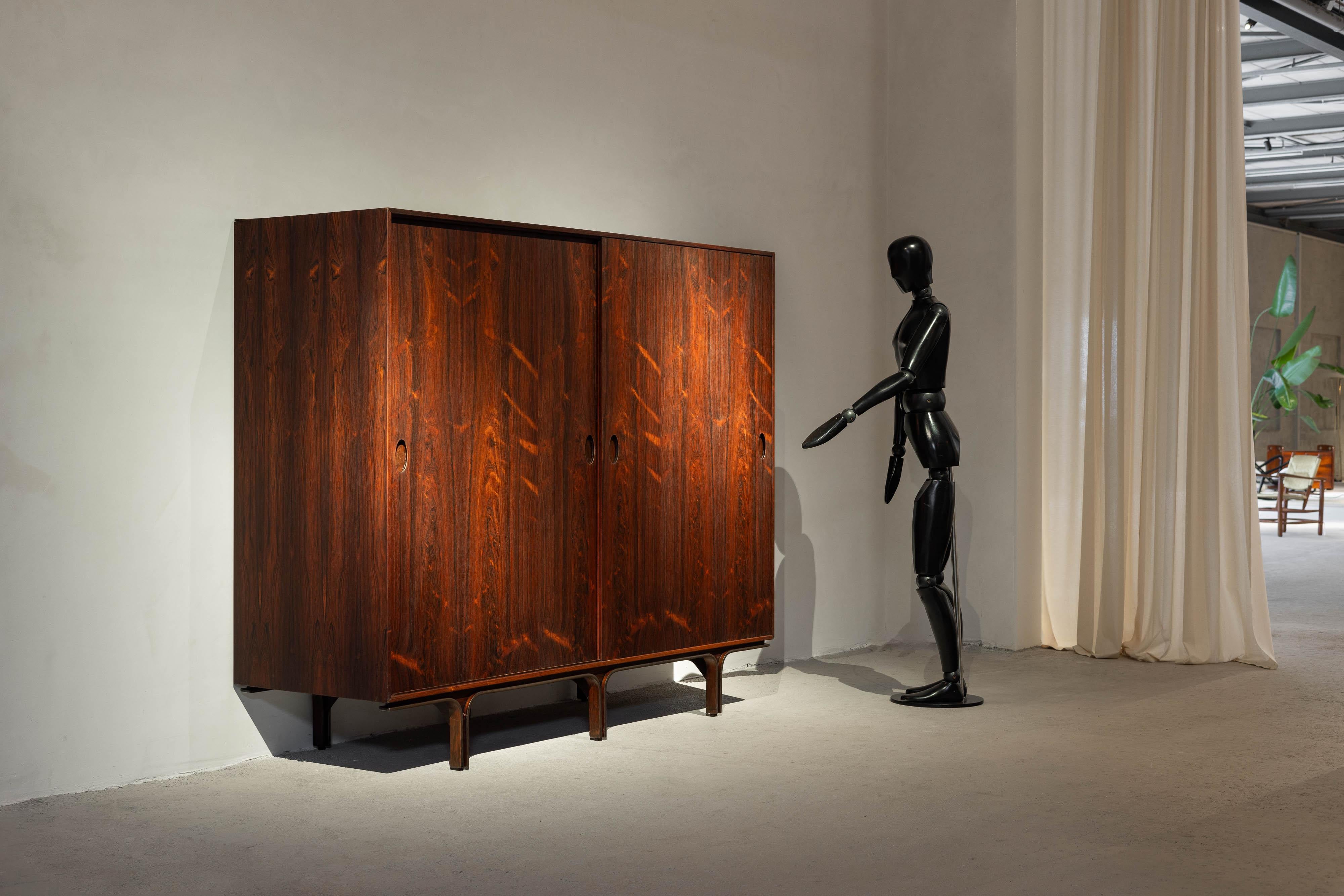 Questo raro armadio ad ante scorrevoli, disegnato dal celebre Gianfranco Frattini e prodotto da Bernini, Italia nel 1957. Incarna la raffinata eleganza del design moderno di metà secolo. Realizzato in lussuoso legno di palissandro, l'armadio