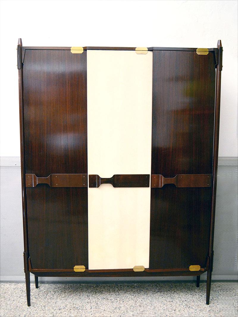 Gianfranco Frattini for Esposizione Permanente Mobil Cantù from the 1950s.
3-door wardrobe in rosewood with original vipla lining with iridescent stripes.
Curved handles, uprights and doors with brass details, wooden and brass clothes hanger.
In