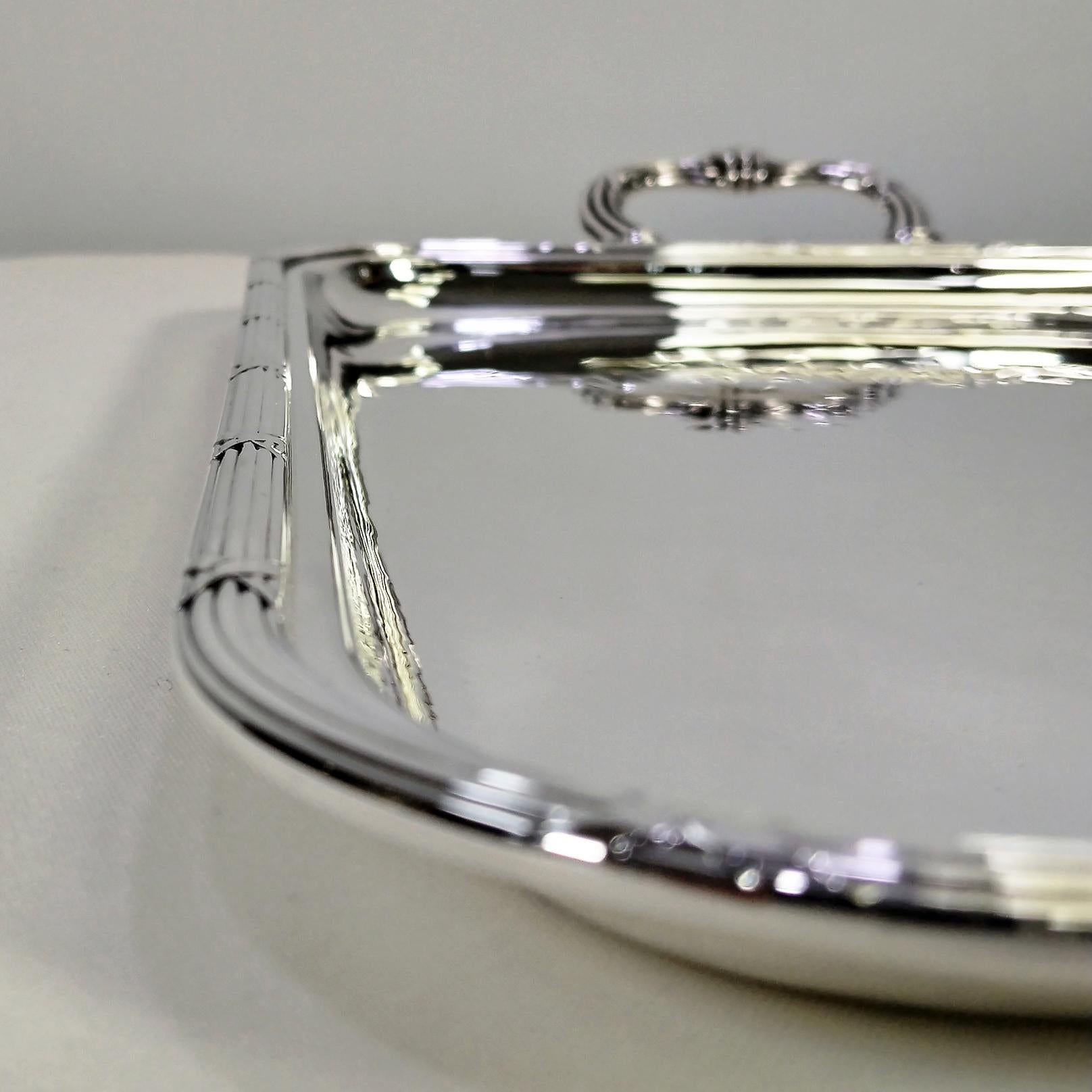 Bandeja rectangular con asas de Gianmaria Buccellati.
La bandeja se hizo totalmente a mano, partiendo de una lámina de plata de ley y martillándola.
Las esquinas de la bandeja son redondeadas.
En el borde se soldó una cenefa de rayas y cintas,