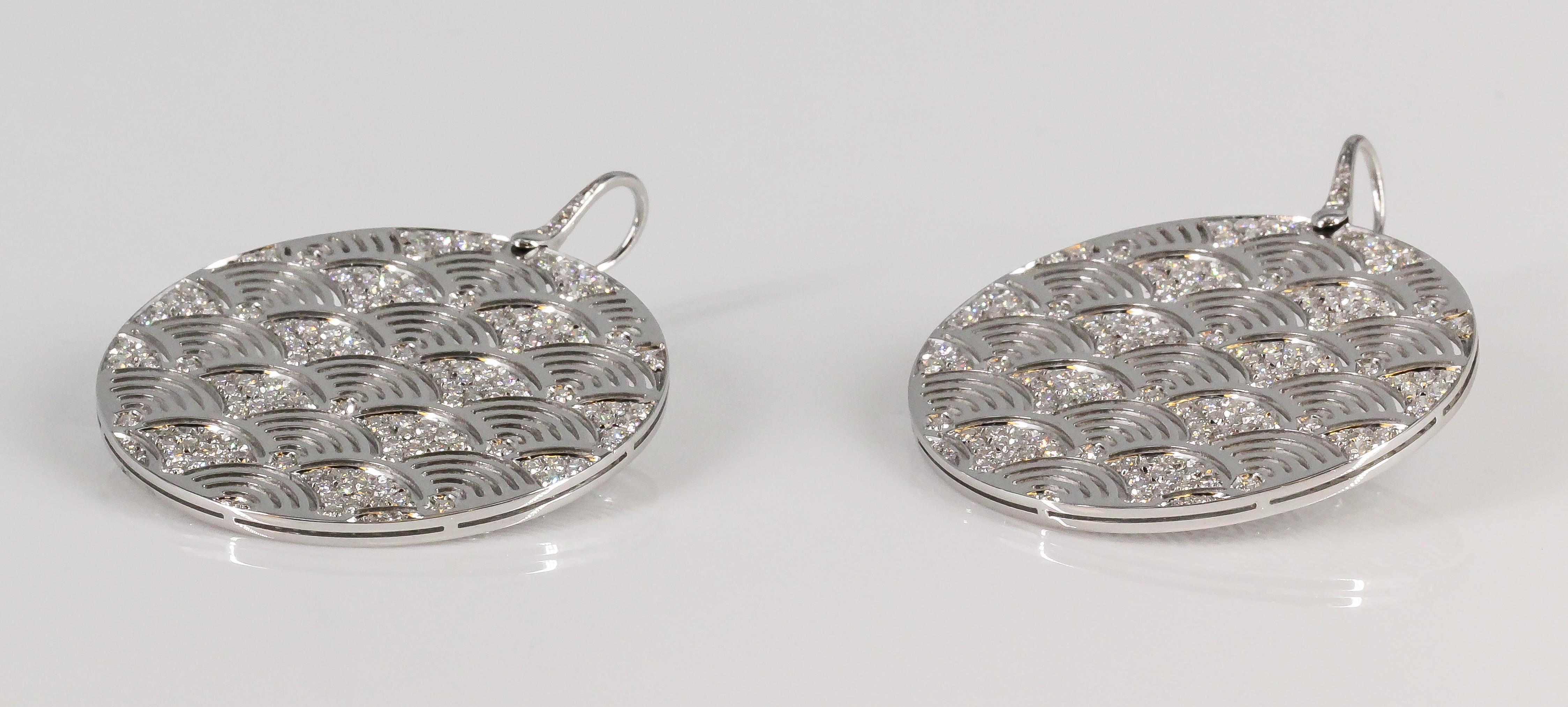 Fine pair of diamond and 18K white gold drop earrings by Enigma, Gianni Bulgari. Designed as hanging circular discs, these earrings are a stunning piece of jewelry that embodies elegance and sophistication. 

The earrings are made of 18k white gold,