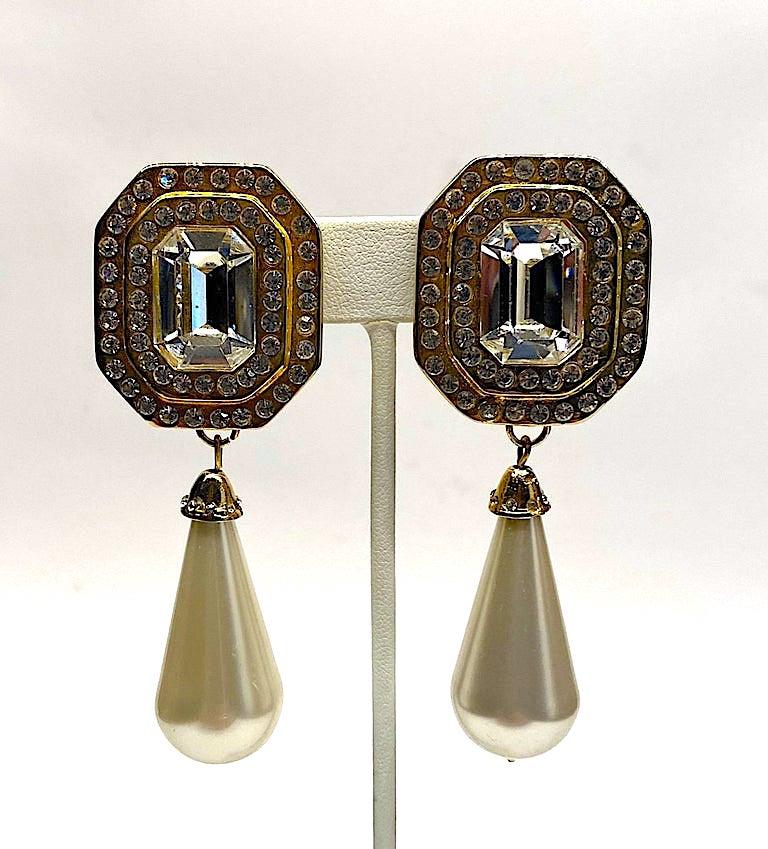 A large statement pair of 1980s gold tone rhinestone and faux pearl pendant earrings by Italian fashion jewelry company Gianni Di Liguoro. The octagon shape top piece is 1.13 inches wide and 1.38 inches long. It is set with a 12 x 17 mm emerald cut