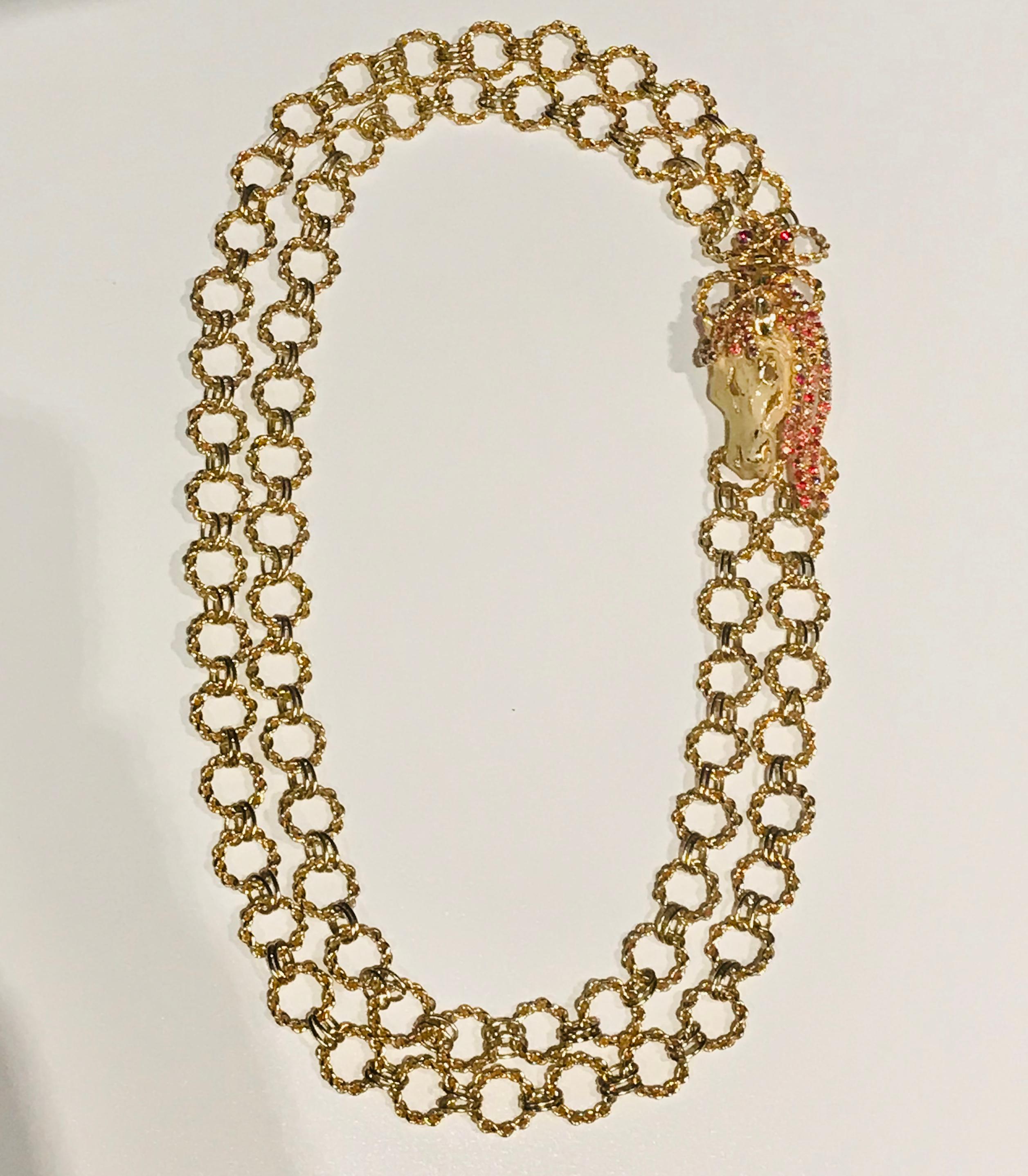 

A beautiful necklace by Italian fashion jewelry company De Liguoro. The necklace has two strands made of small oval and larger round chain links. The two strands come together at a beautiful cast and three dimensional ivory enameled horse head