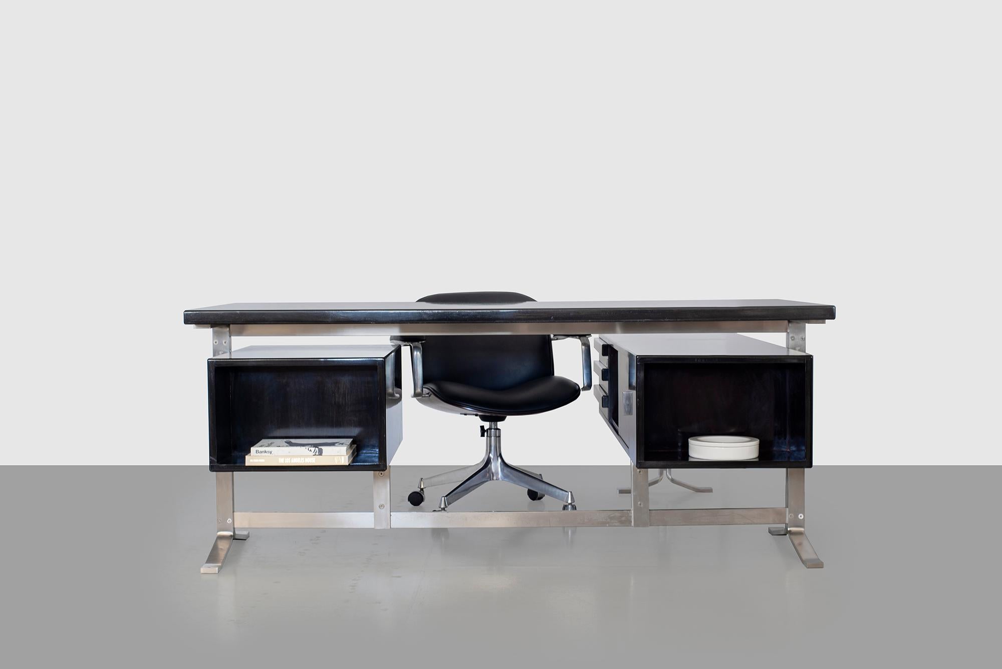 Handsome executive desk by Gianni Moscatelli for Forma Nova. Newly refinished in a dark ebony stain with polished finish. Desk surface rests on flat stainless steel legs with floating drawers on either side. Stamped Formanova on each leg.
Desk top
