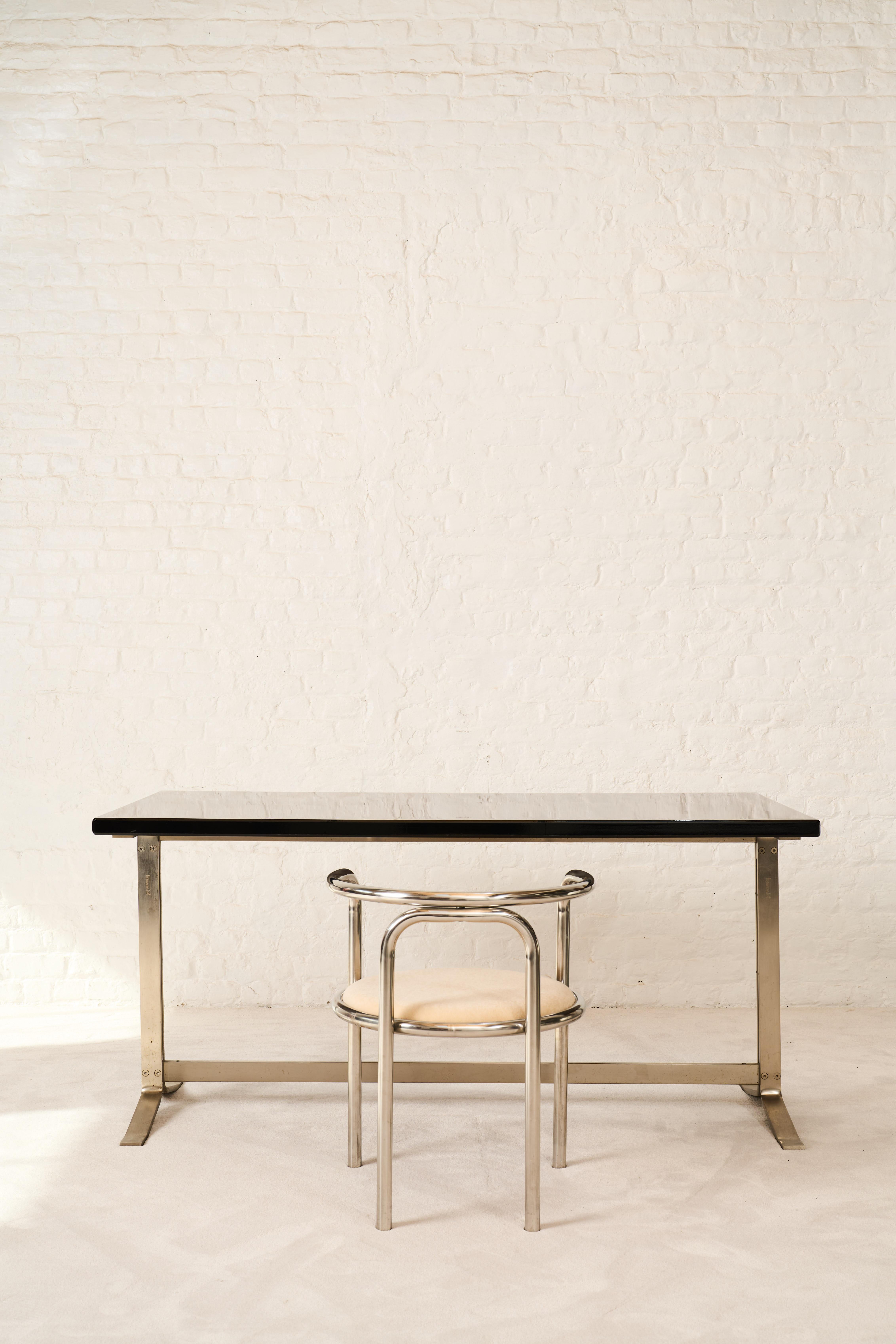 This modern, stream-lined writing desk is designed by Gianni Moscatelli in the sixties in Italy for Formanova. Its notable feature is a spacious wooden lacquered tabletop, firmly affixed to a nickel-plated steel frame distinguished by its sleek,