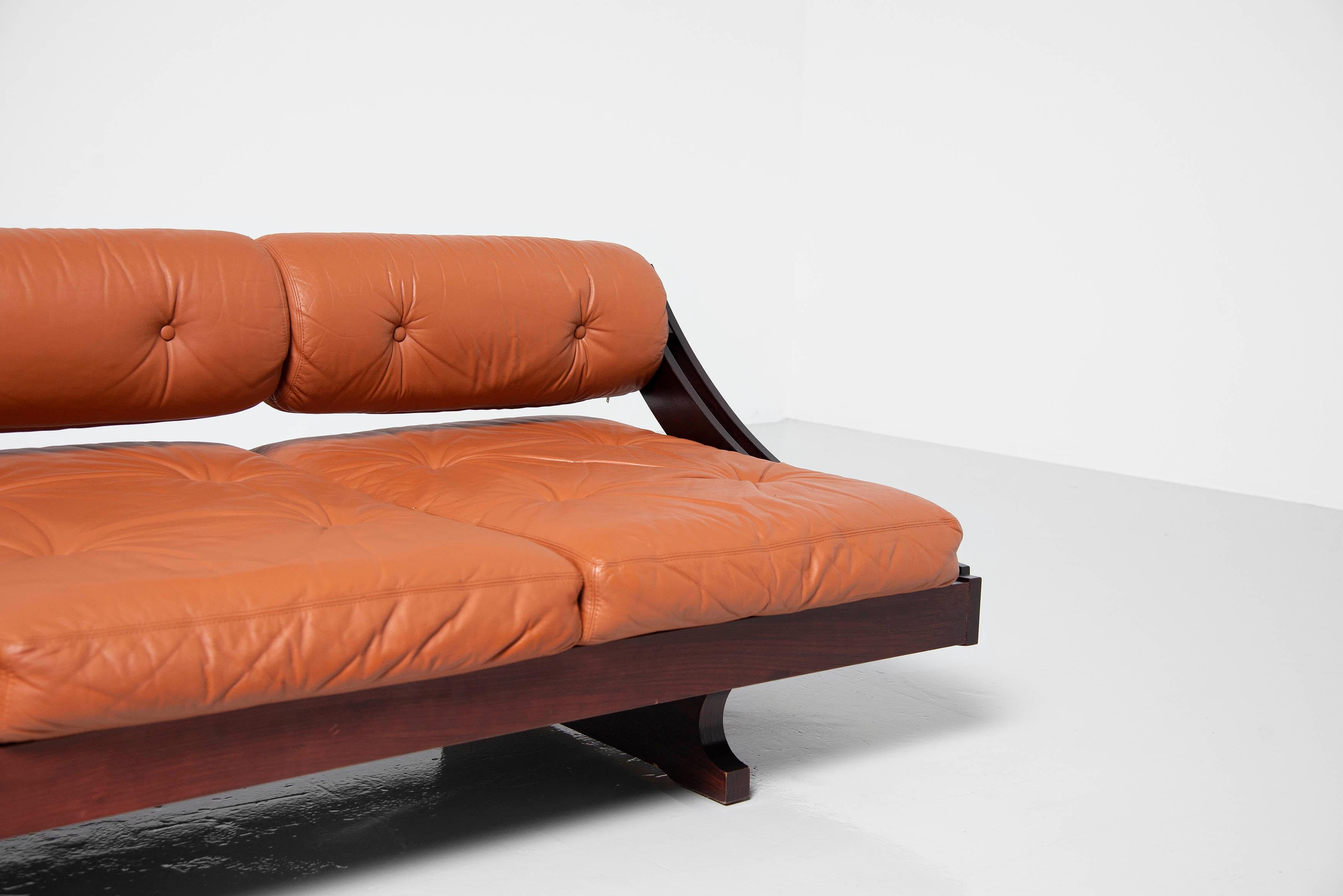 Functional and elegant multi functional lounge sofa/daybed model GS195 designed by Gianni Songia and manufactured by Sormani, Italy 1963. This sofa has a sculptural rosewood sliding frame and very nice original cognac leather cushions and seating.