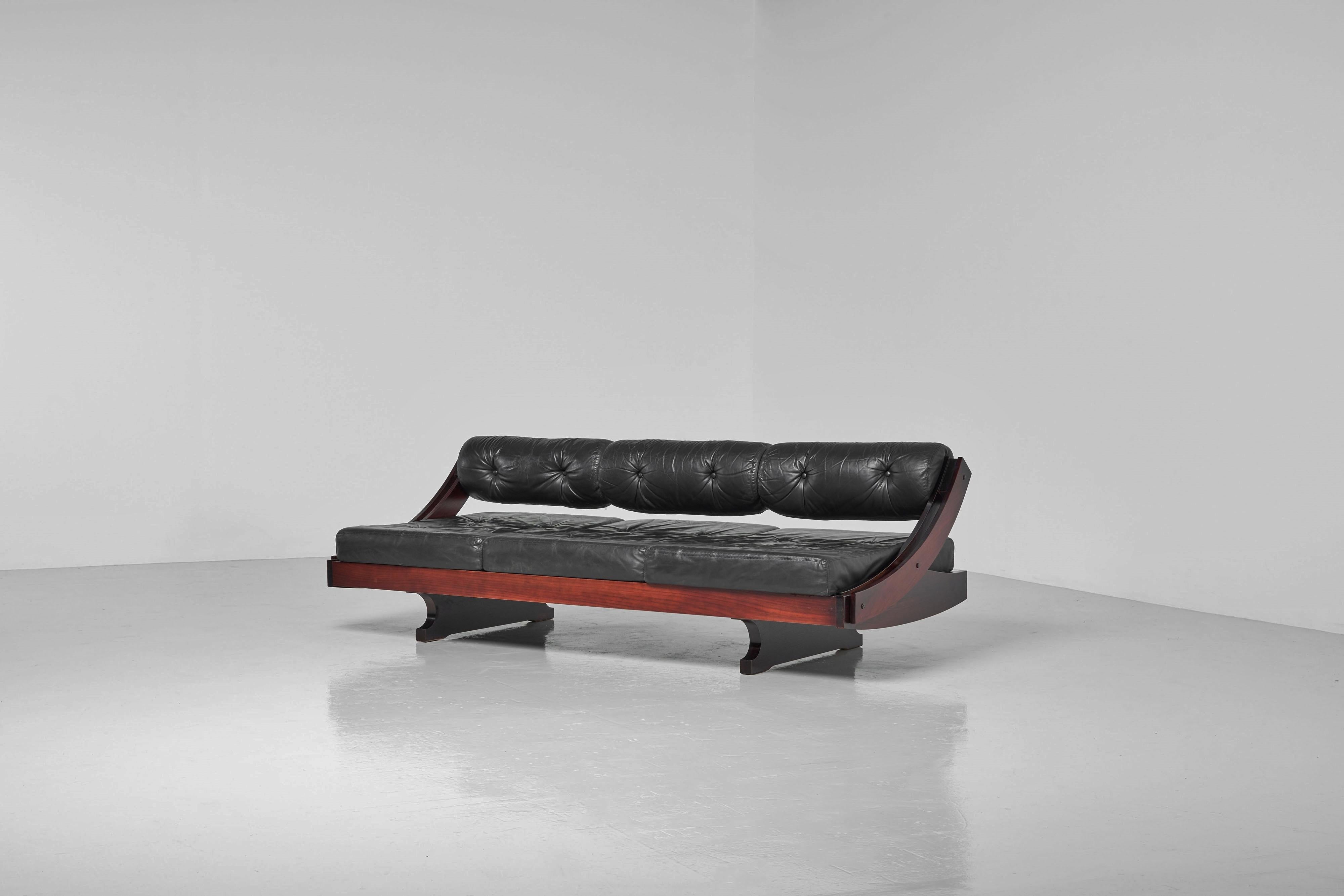 Great lounge sofa-daybed model GS195 designed by Gianni Songia for Sormani in Italy 1963. The GS195 features a sculptural mahogany sliding frame. Its original black leather cushions and seating provide both comfort and style. With just one hand, you