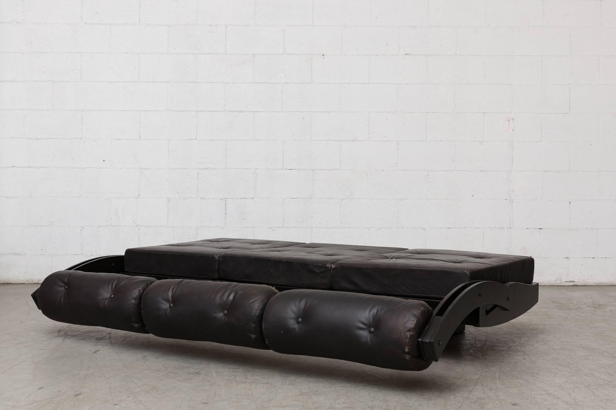 Undeniably Italian in design by Gianni Songia for Sormani, 1963, Italy. Converts into a daybed via a sliding backrest. Painted wood frame with original black leather cushions. Visible wear and patina.