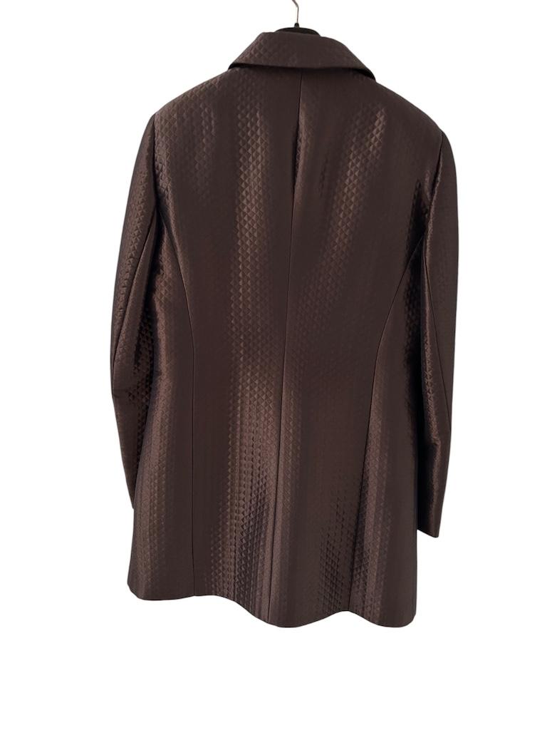 Diese üppige und doch dezente Jacke von Gianni Tolentino Milano zeigt das Talent des Designers, Couture-Techniken in moderne Abendkleider zu übersetzen. Der in Italien aus einem glänzenden schokoladenbraunen Jacquard geschnittene Stoff schimmert