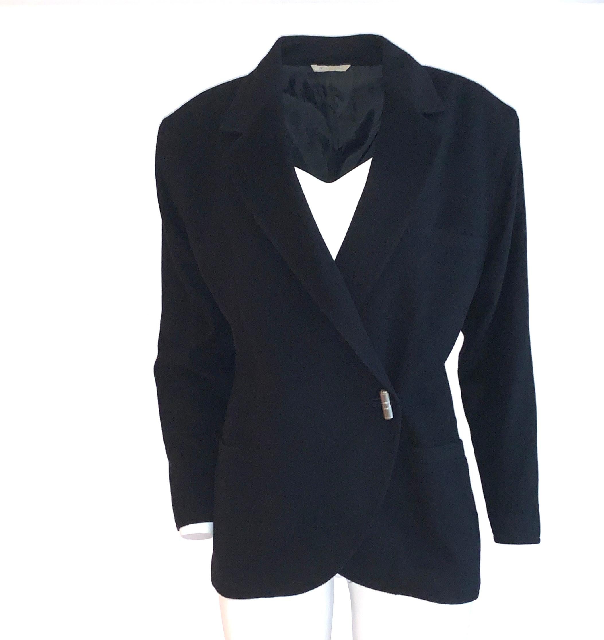 Vintage Gianni Versace blazer in a soft fleecy black wool with silver buttons that resemble toggles at front and cuff. (They just function like buttons.) Slightly boxy fit with light padding at shoulders. Long sleeve, jacket fastens with an interior