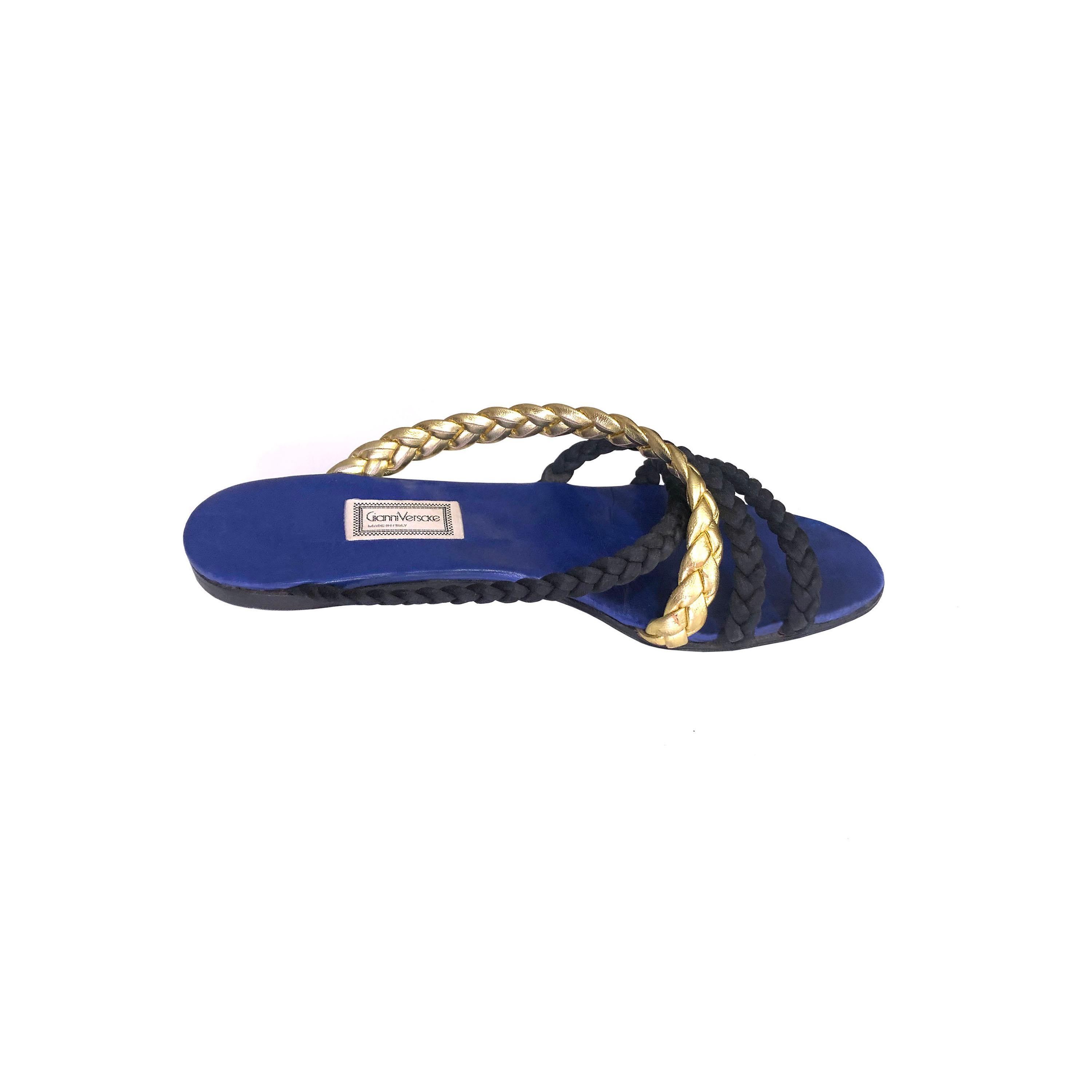 Product Details: Gianni Versace - 1980s Vintage - Sandals - Gold Leather + Black Cord Plaited Front Strap Detailing - Electric Blue Leather Soles - Made in Italy 
Era: 1980s Vintage
Label: Gianni Versace
Size: EU 37.5
Fabric Content: Leather +