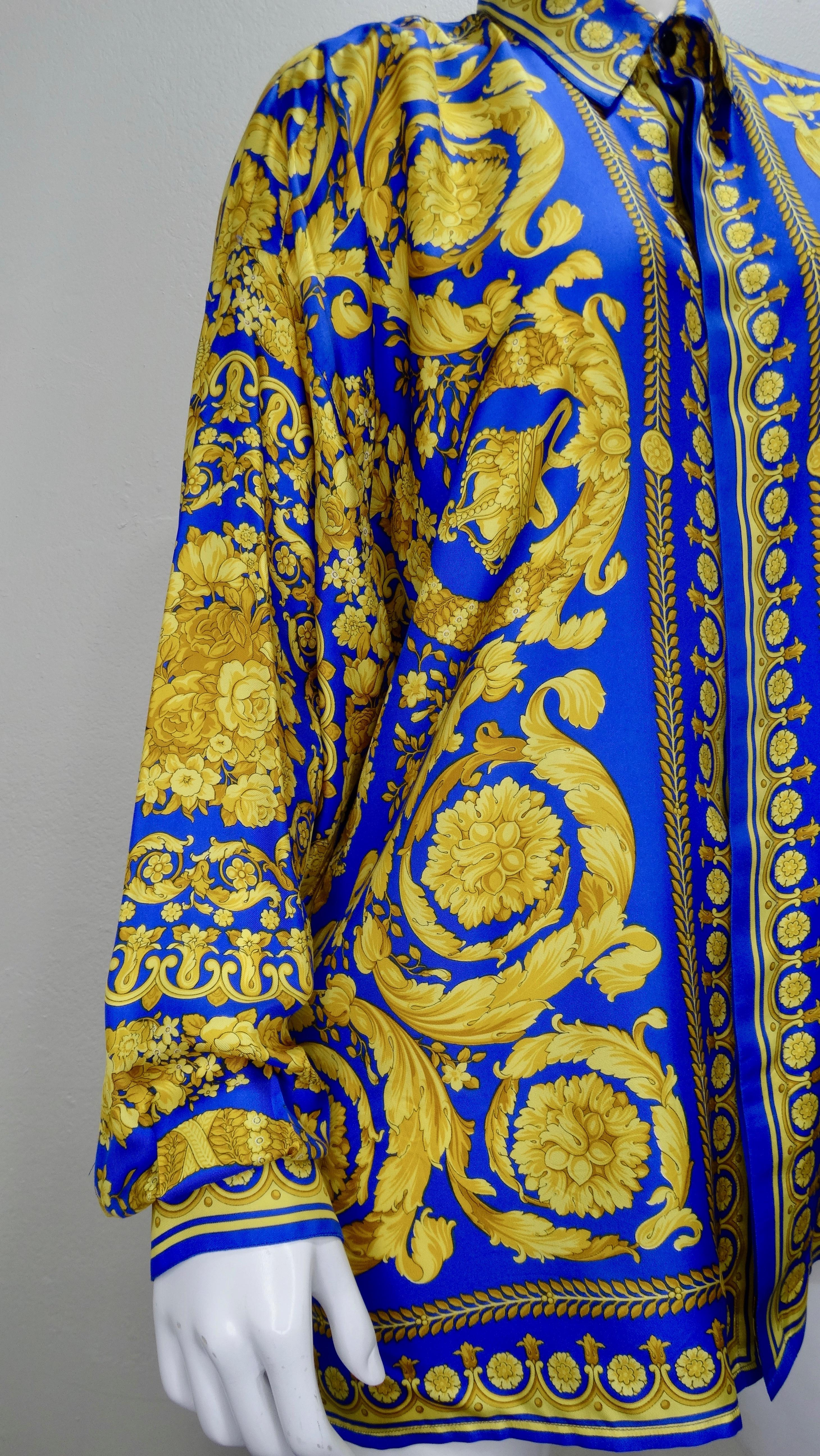 We all need a classic Versace Silk shirt in our wardrobe! Circa 1990s, this royal blue and gold Versace Silk long sleeve button up features one of Gianni Versace's signature Baroque style prints mixed with floral arrangements and crowns. Includes a