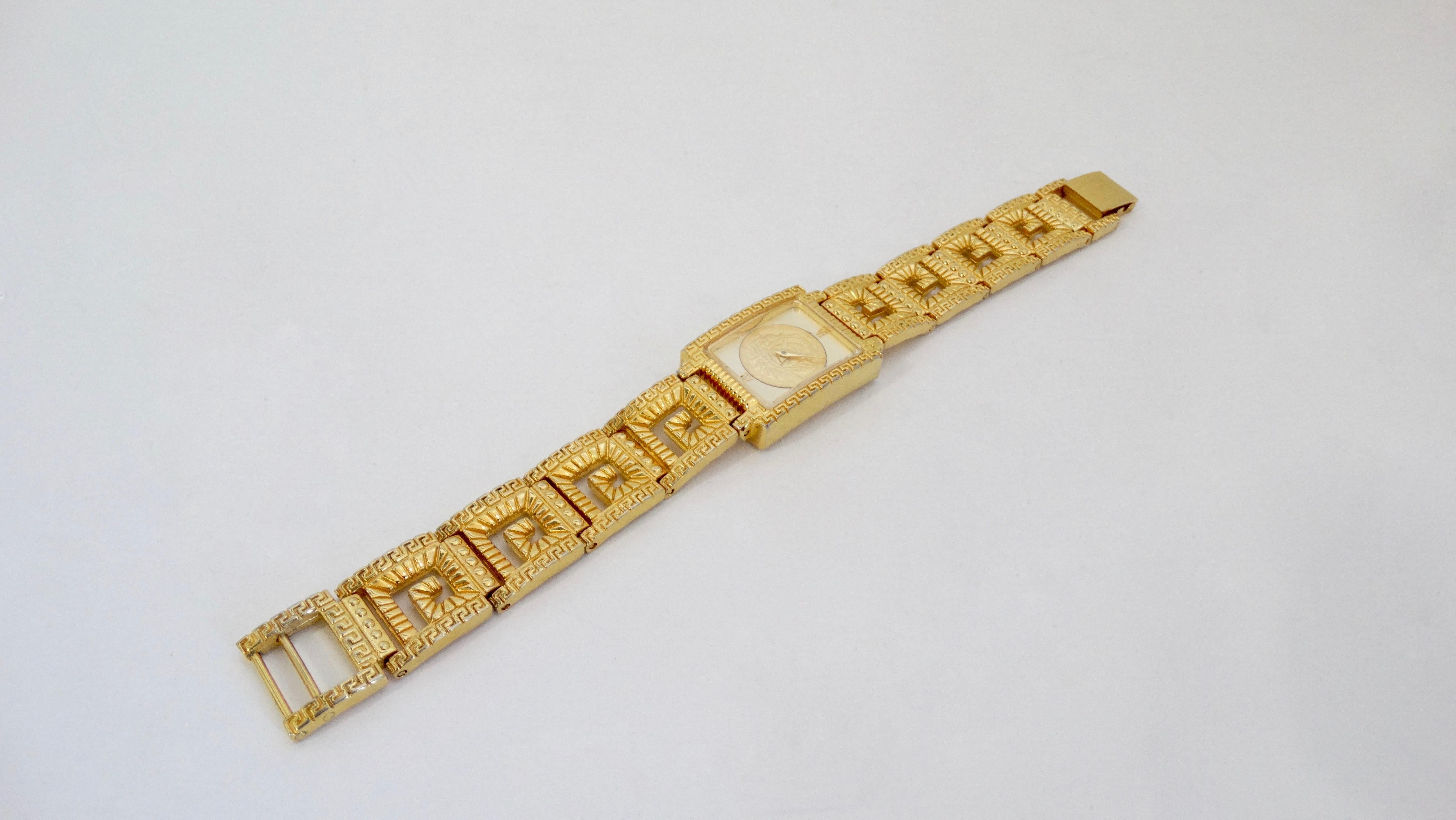 Add something from the Versace archives to your collection! Circa early 1990s, this gold plated Versace wrist watch features a Greek key bracelet with a mini Greek Key trim, a latch closure, and a square face with a white dial, gold arms and Roman