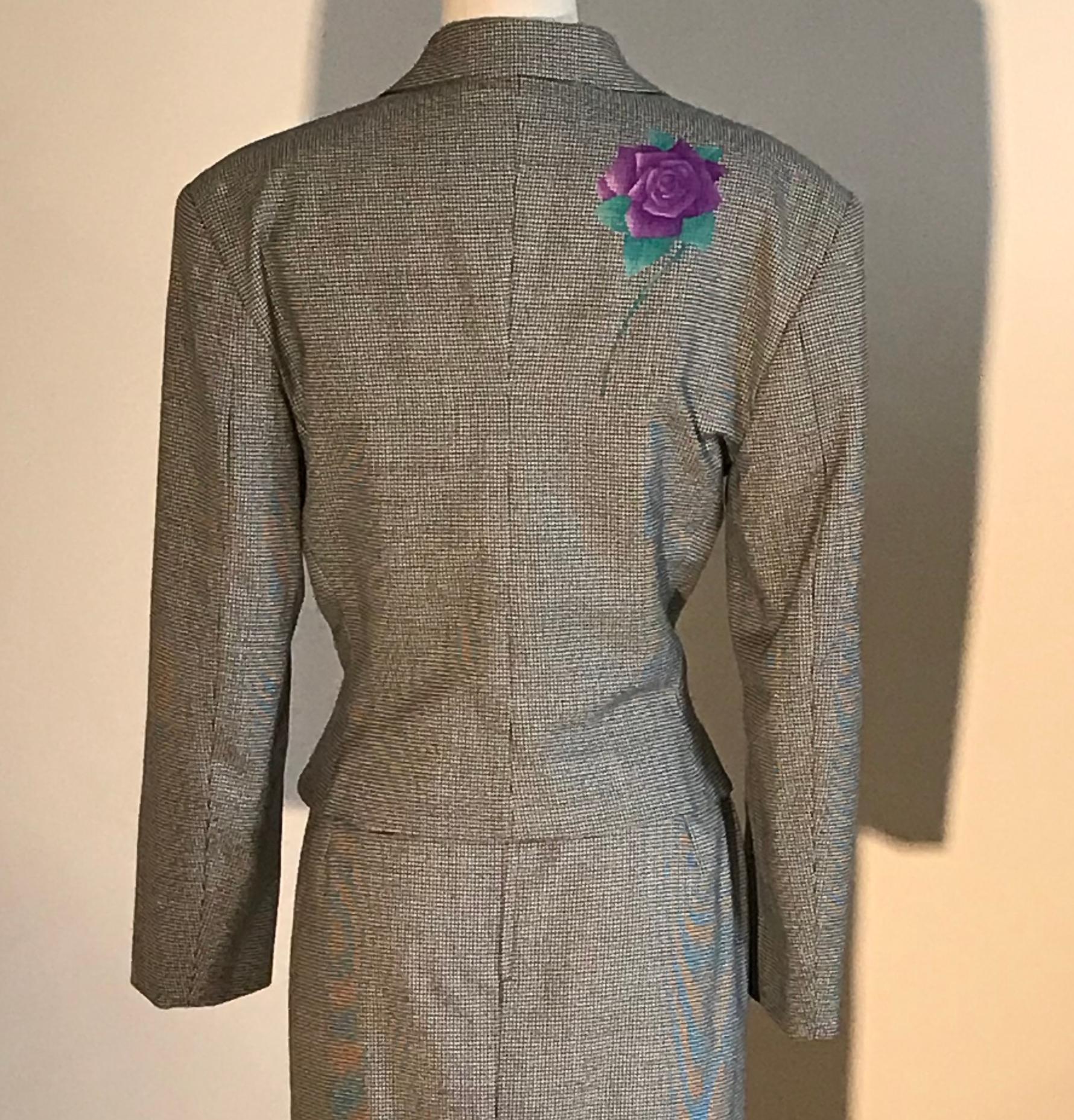 Gianni Versace vintage wool blazer in black and white houndstooth or dogtooth check. Purple and green roses printed at jacket bust, one sleeve, and back. Jacket features purple Versace logo buttons with rhinestone detail. Medium padding at