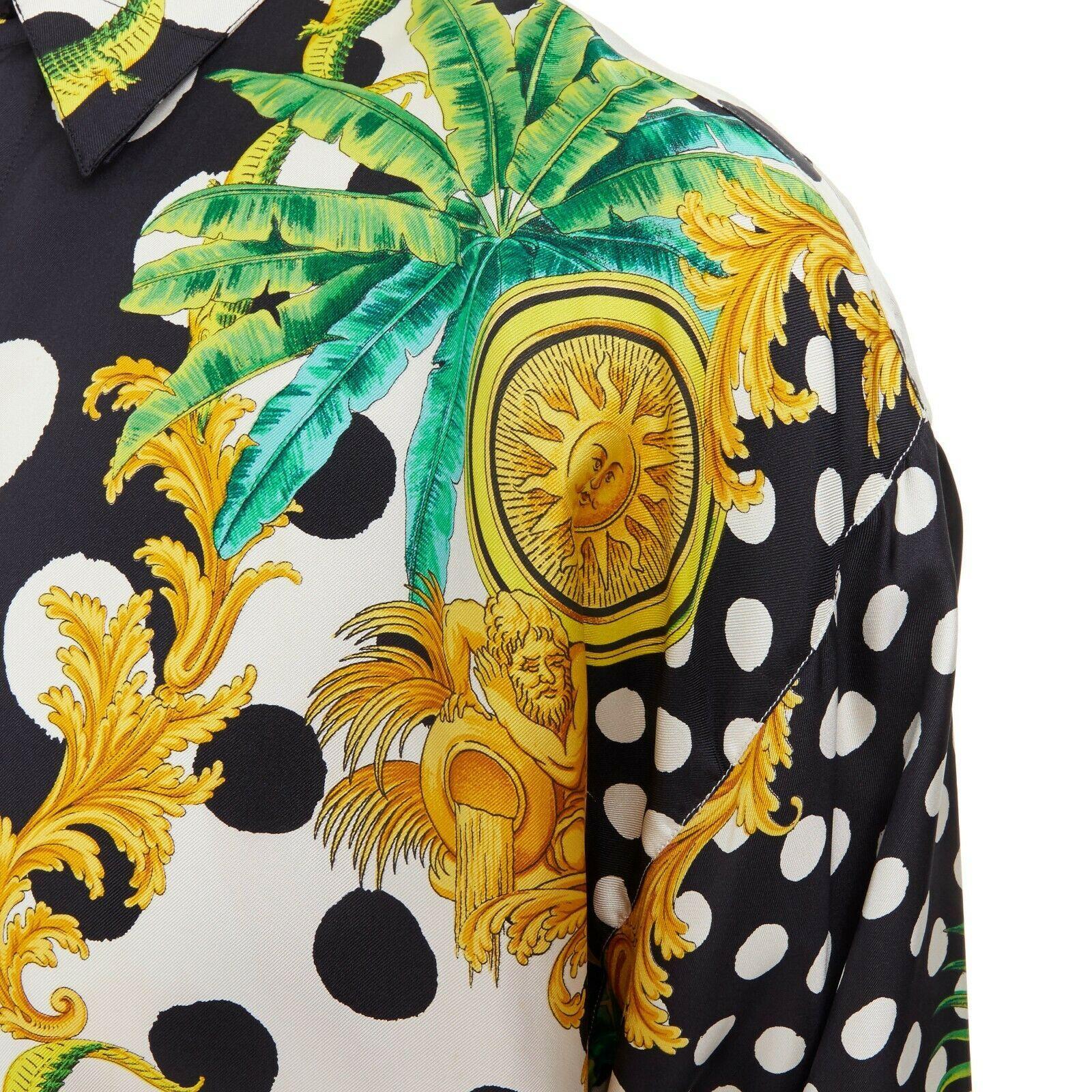 GIANNI VERSACE 1993 black white polka dot palm tree medallion silk shirt IT46 S

GIANNI VERSACE
FROM THE 1993 COLLECTION100% silk. Black and white enlarged polka dot print. Green and gold palm tree crocodile print. Concealed button at collar. Button